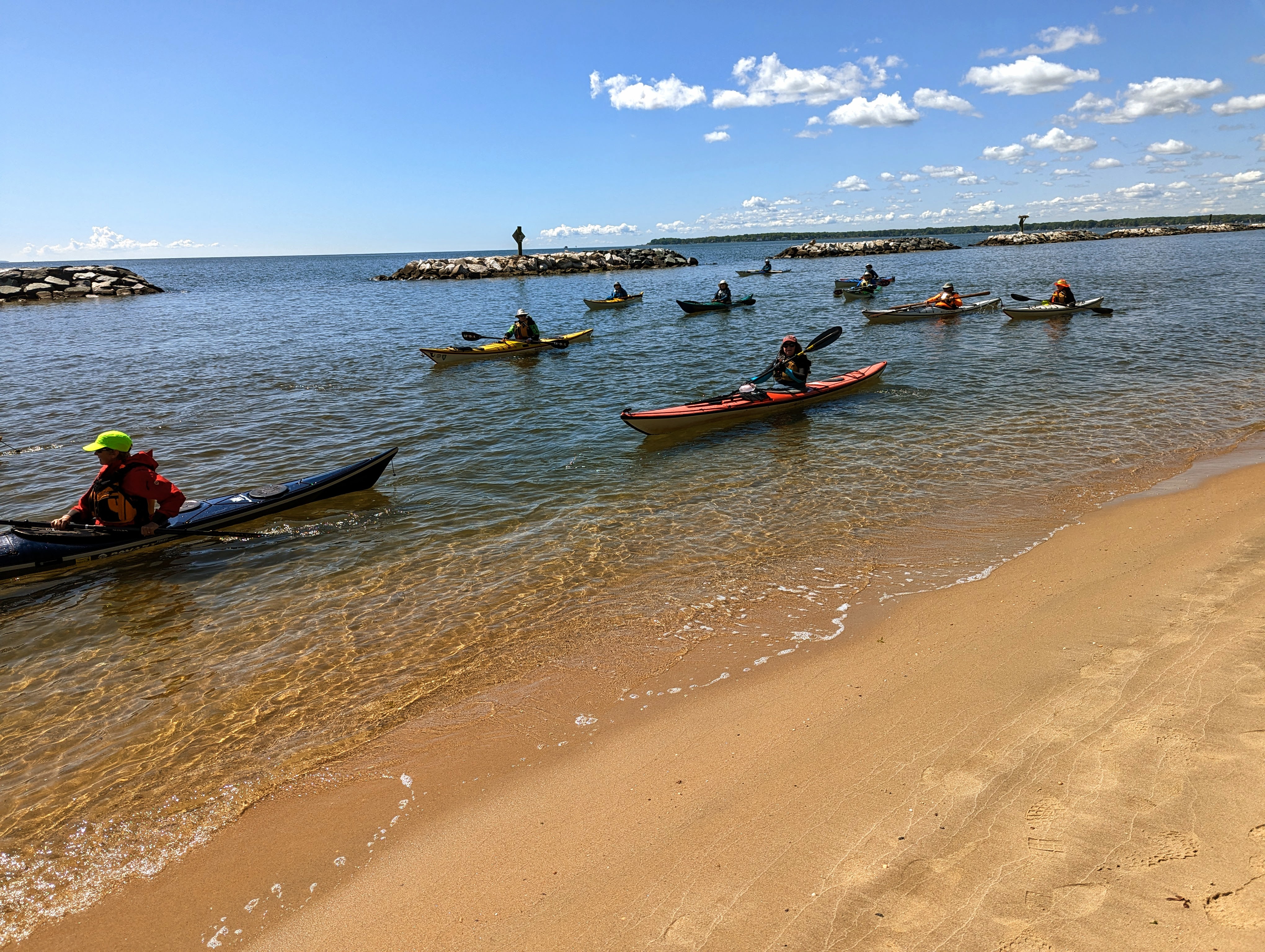 Kayakers paddle along the golden sand beach at Beverly Triton Nature Park just before a dedication ceremony on Friday, May 5. The beach will open for swimming this summer.