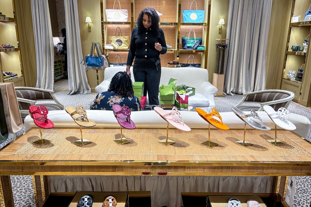 Meehla Franklin, a sales associate at Tory Burch, helps a customer buy shoes. Tory Burch is the last of the luxury shops in that wing of the Towson Town Center mall in Towson, MD.