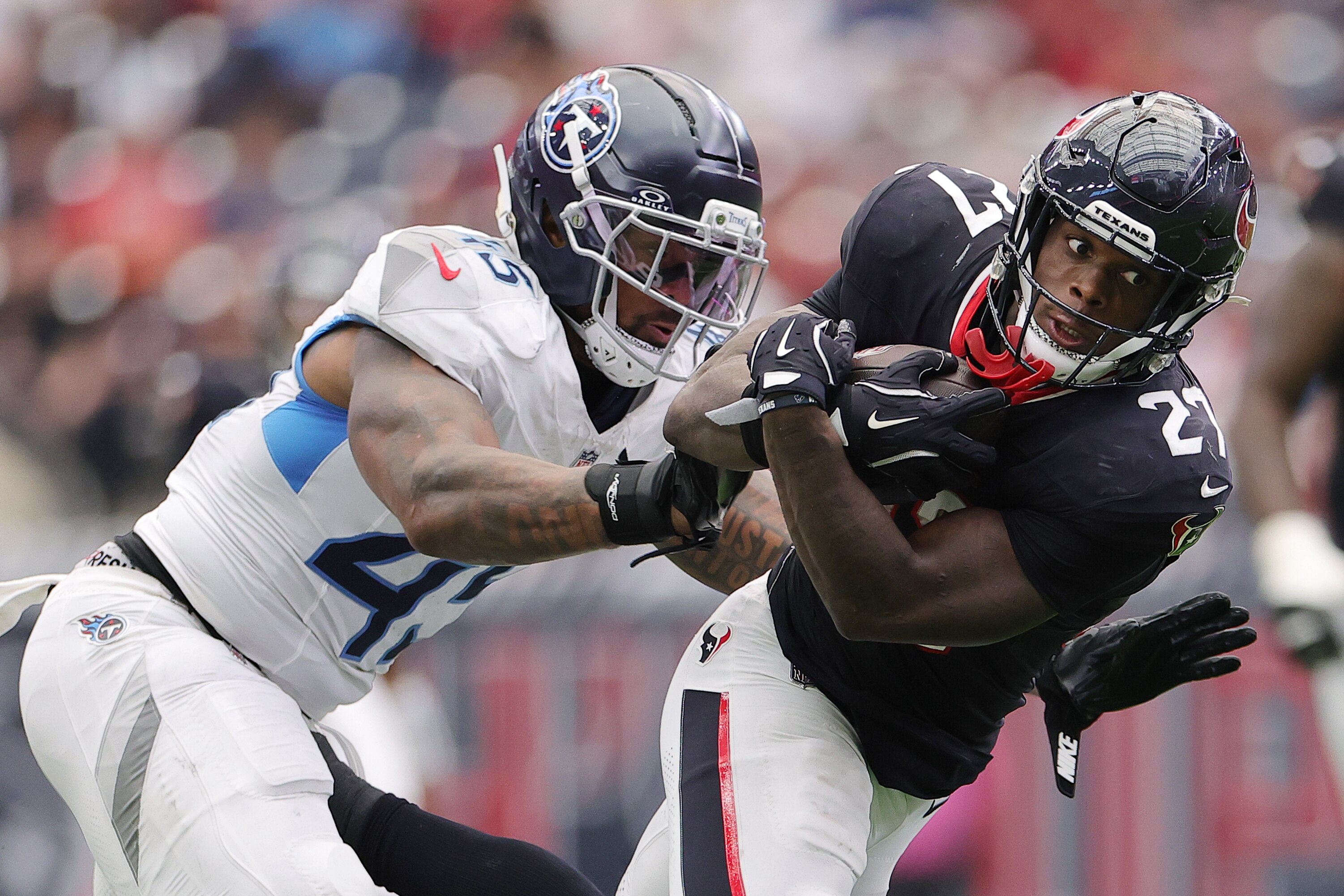 HOUSTON, TEXAS - SEPTEMBER 28: Woody Marks #27 of the Houston Texans is tackled by Dre'Mont Jones #45 of the Tennessee Titans during the fourth quarter in the game at NRG Stadium on September 28, 2025 in Houston, Texas. (Photo by Alex Slitz/Getty Images)