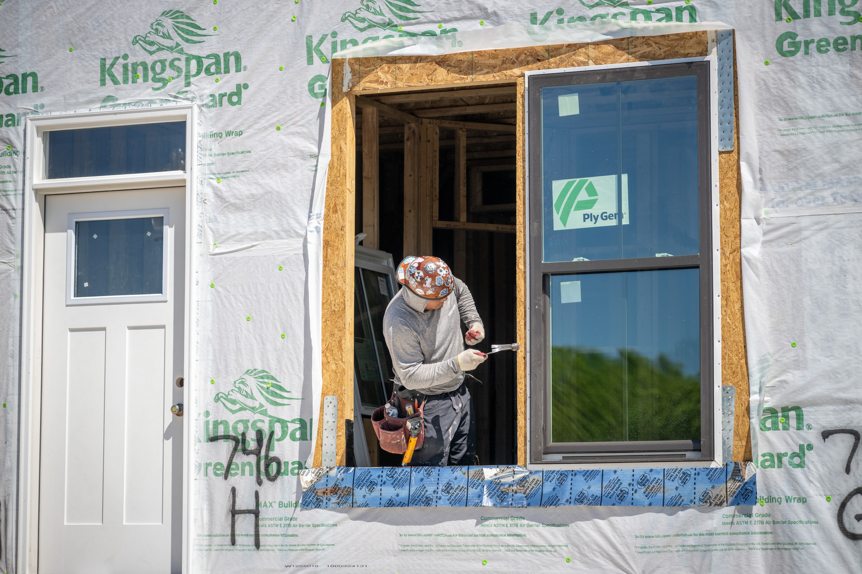 A construction worker installs windows at Reservoir Square, an eight-acre, $170 million mixed-use development currently under construction at 600-800 West North Avenue.