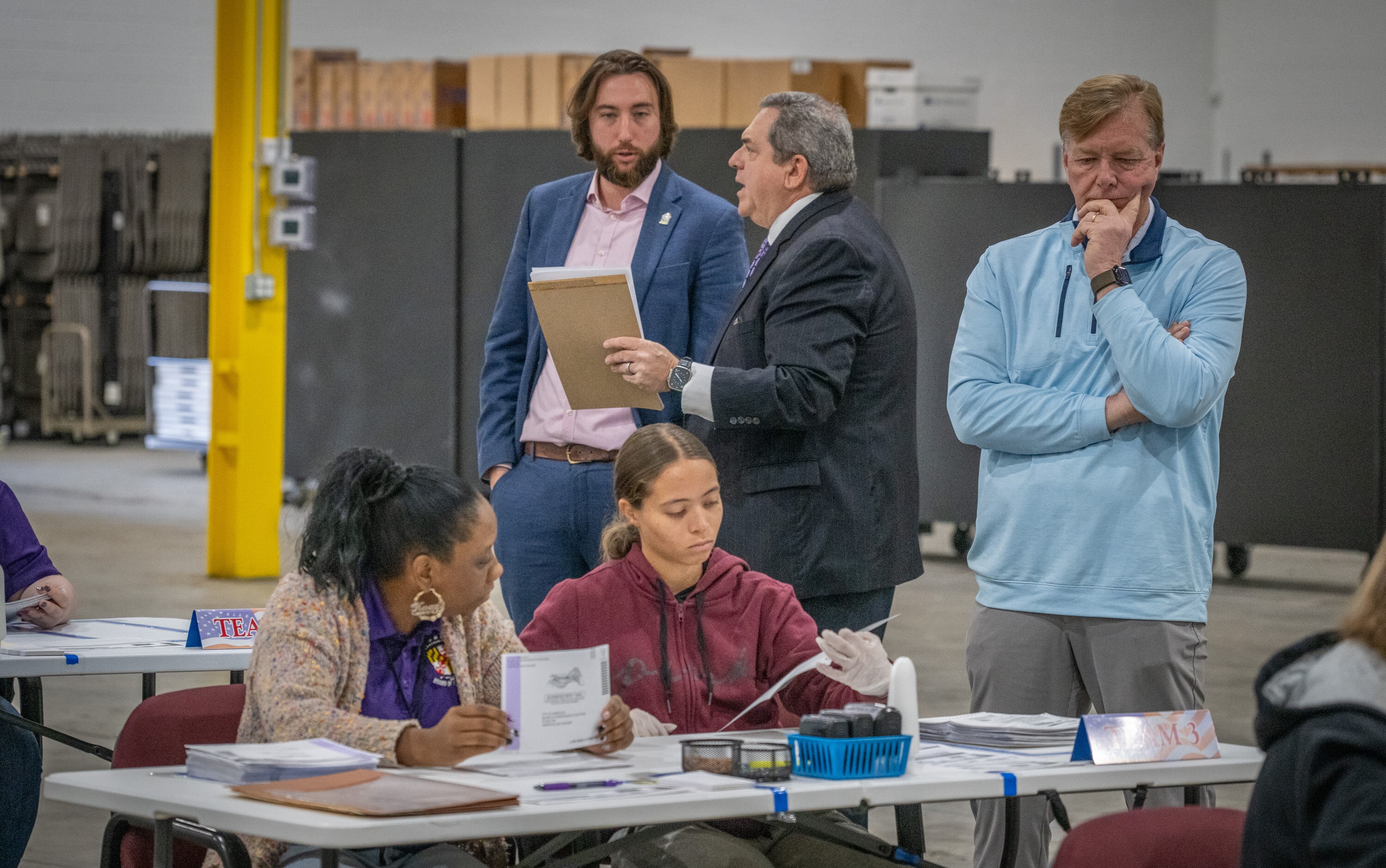 Annapolis Ward 1 alderperson Harry Huntley, left, talks with his lawyer Jonathan Kagan on Thursday as his opponent, Thomas Krieck, in blue, observes election workers sorting and counting mail-in ballots at the Anne Arundel County Board of Elections in Glen Burnie.