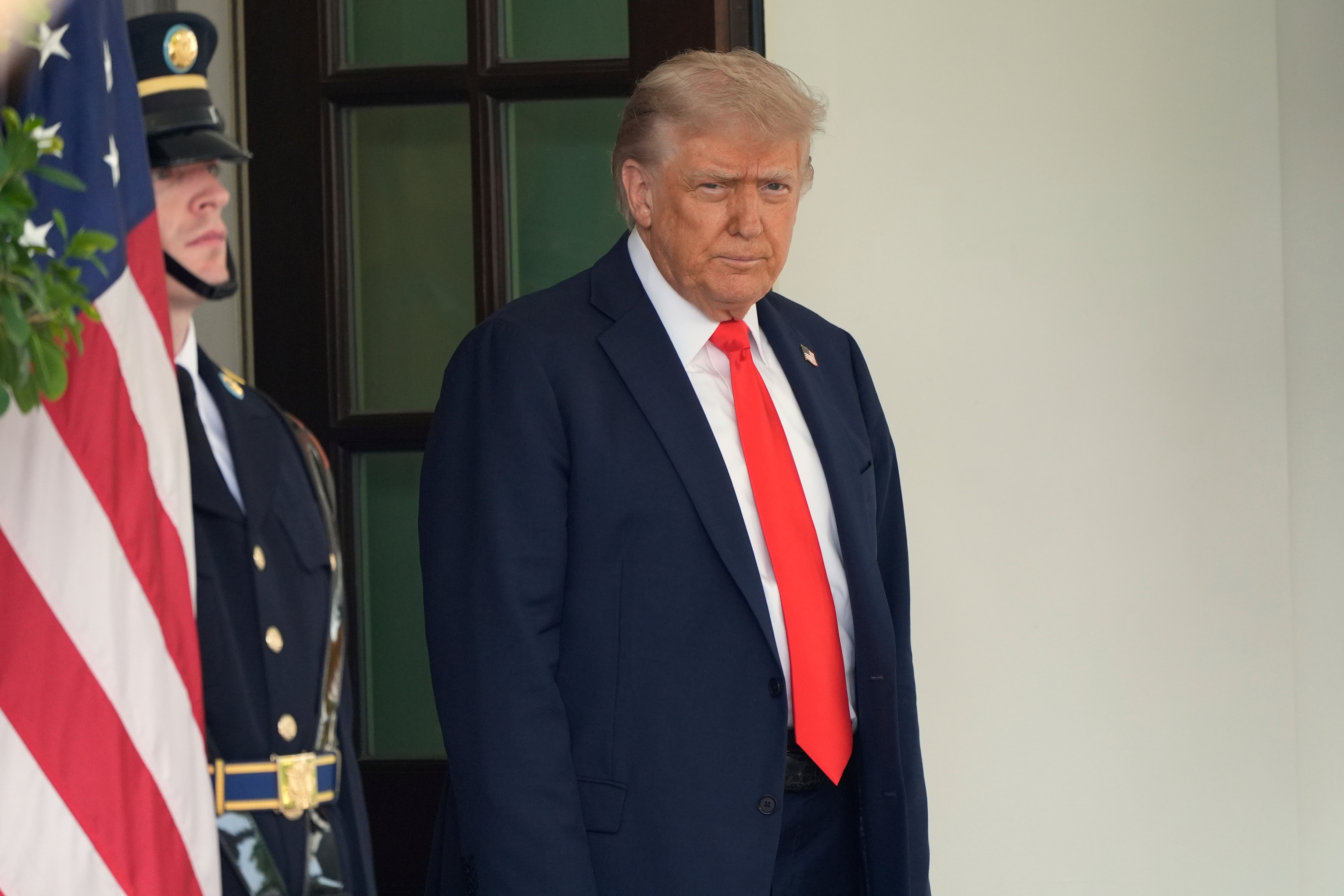 President Donald Trump stands before greeting Germany's Chancellor Friedrich Merz before his arrival at the White House, Thursday, June 5, 2025, in Washington.