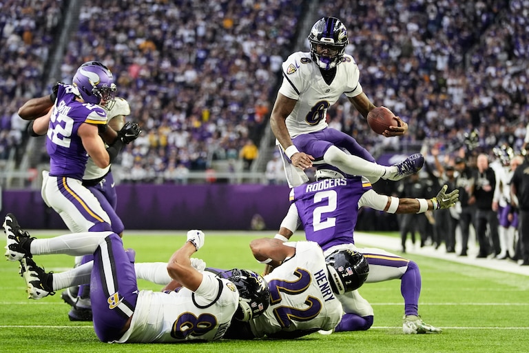 Baltimore Ravens quarterback Lamar Jackson (8) hurdles over Minnesota Vikings cornerback Isaiah Rodgers (2) near the goal line in the second half of an NFL football game, Sunday, Nov. 9, 2025, in Minneapolis.