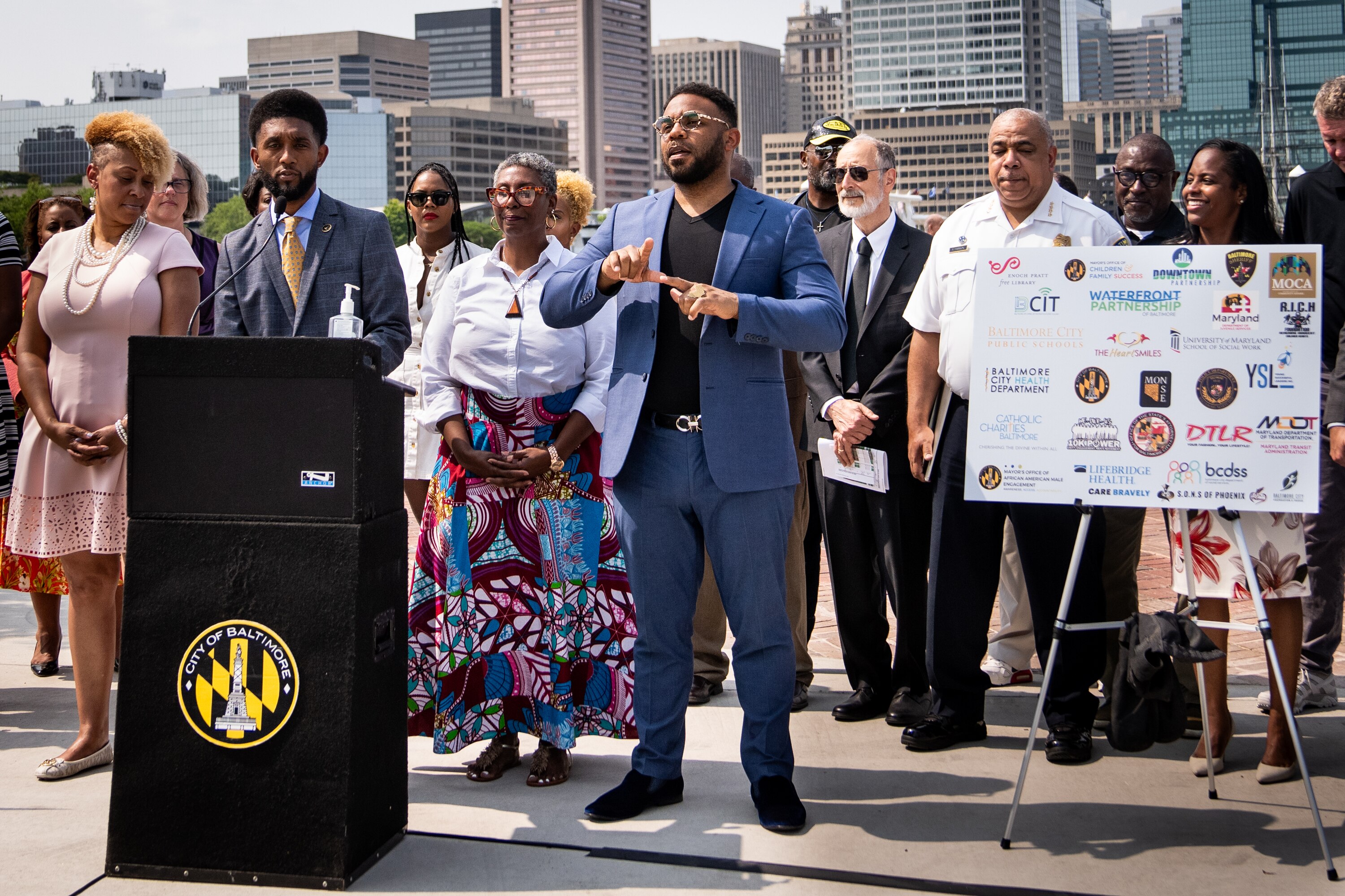 Interpreter Billy Sanders joins Mayor Brandon Scott, during an announcement of the city's strategy to address teen violence, including enforcement of the youth curfew, at a press conference on May 24, 2023.