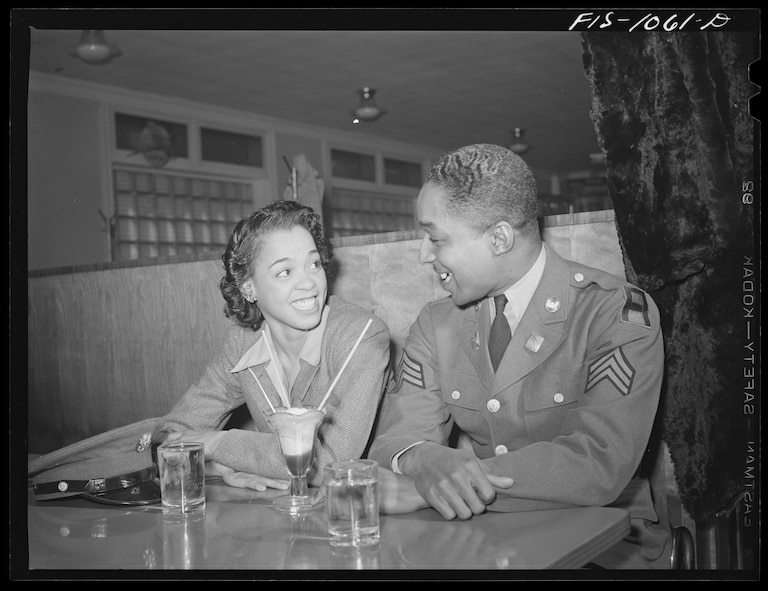 Baltimore, Maryland. Sargeant Franklin Williams, home on leave from Army duty, with his best girl Ellen Hardin, splitting a soda. They met at Douglas High School
