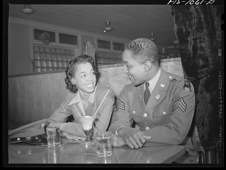 Baltimore, Maryland. Sargeant Franklin Williams, home on leave from Army duty, with his best girl Ellen Hardin, splitting a soda. They met at Douglas High School