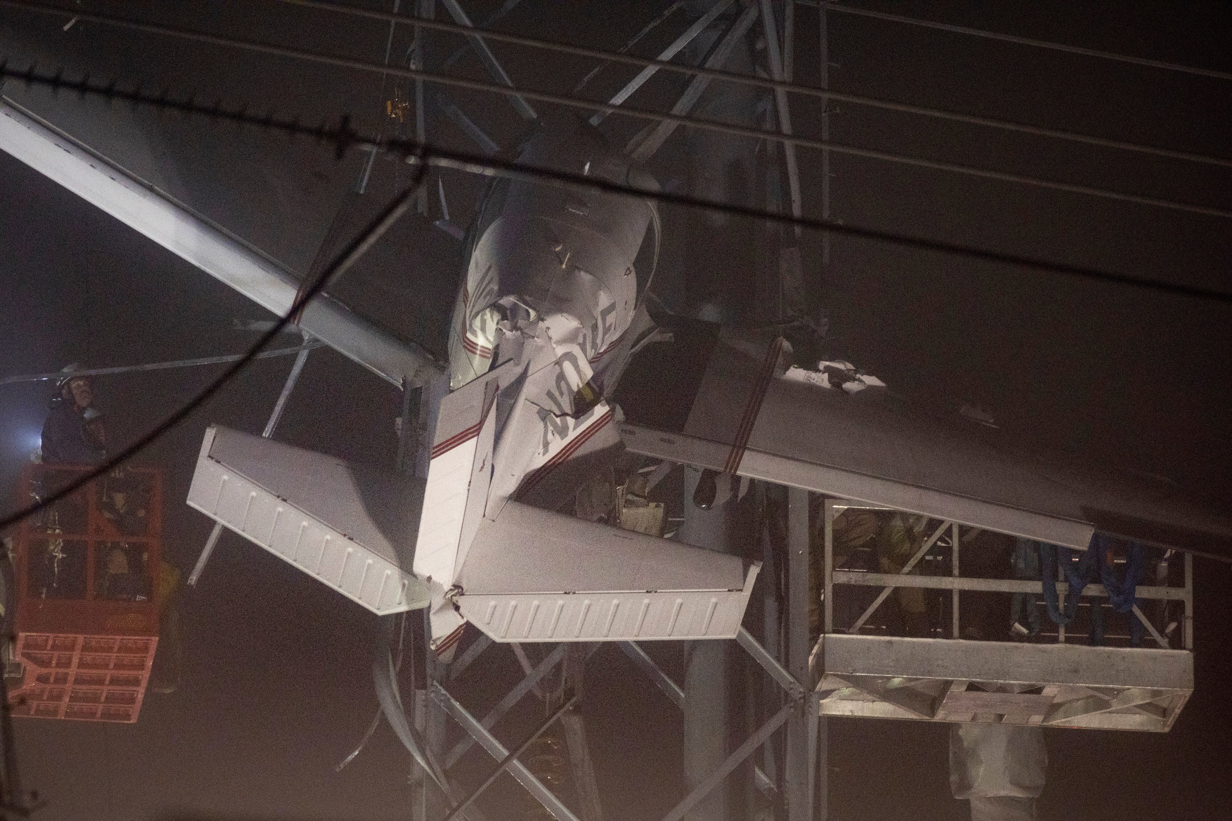 First responders work to rescue aircraft passengers after the small plane crashed and became stuck in live power lines, Monday, Nov. 28, 2022, in Montgomery Village, a northern suburb of Gaithersburg, Md. Both occupants were successfully rescued.