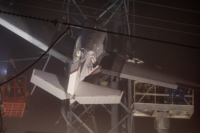 First responders work to rescue aircraft passengers after the small plane crashed and became stuck in live power lines, Monday, Nov. 28, 2022, in Montgomery Village, a northern suburb of Gaithersburg, Md. Both occupants were successfully rescued.