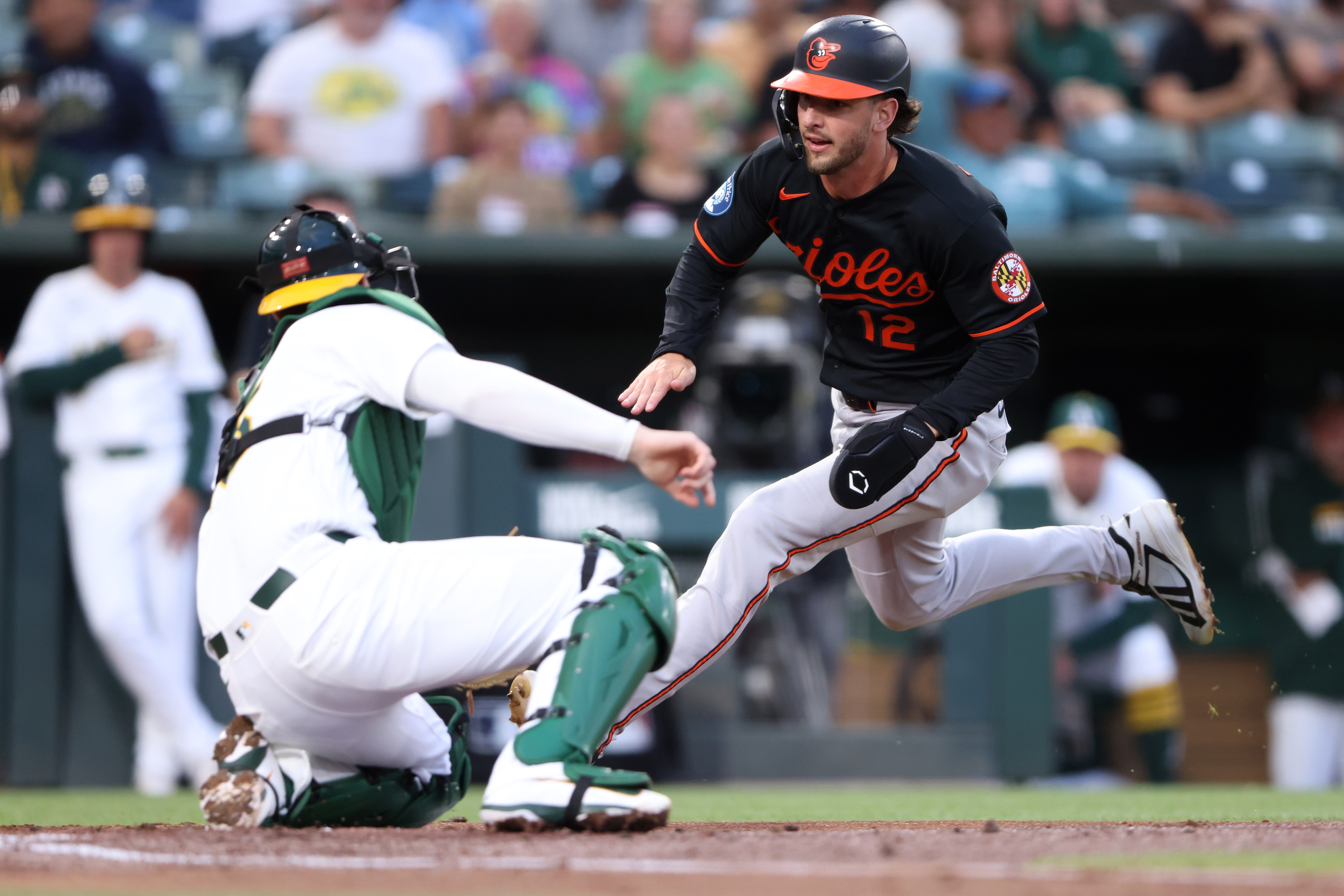Dylan Beavers is out on a tag by Athletics catcher Jonah Heim during the second inning Friday night.