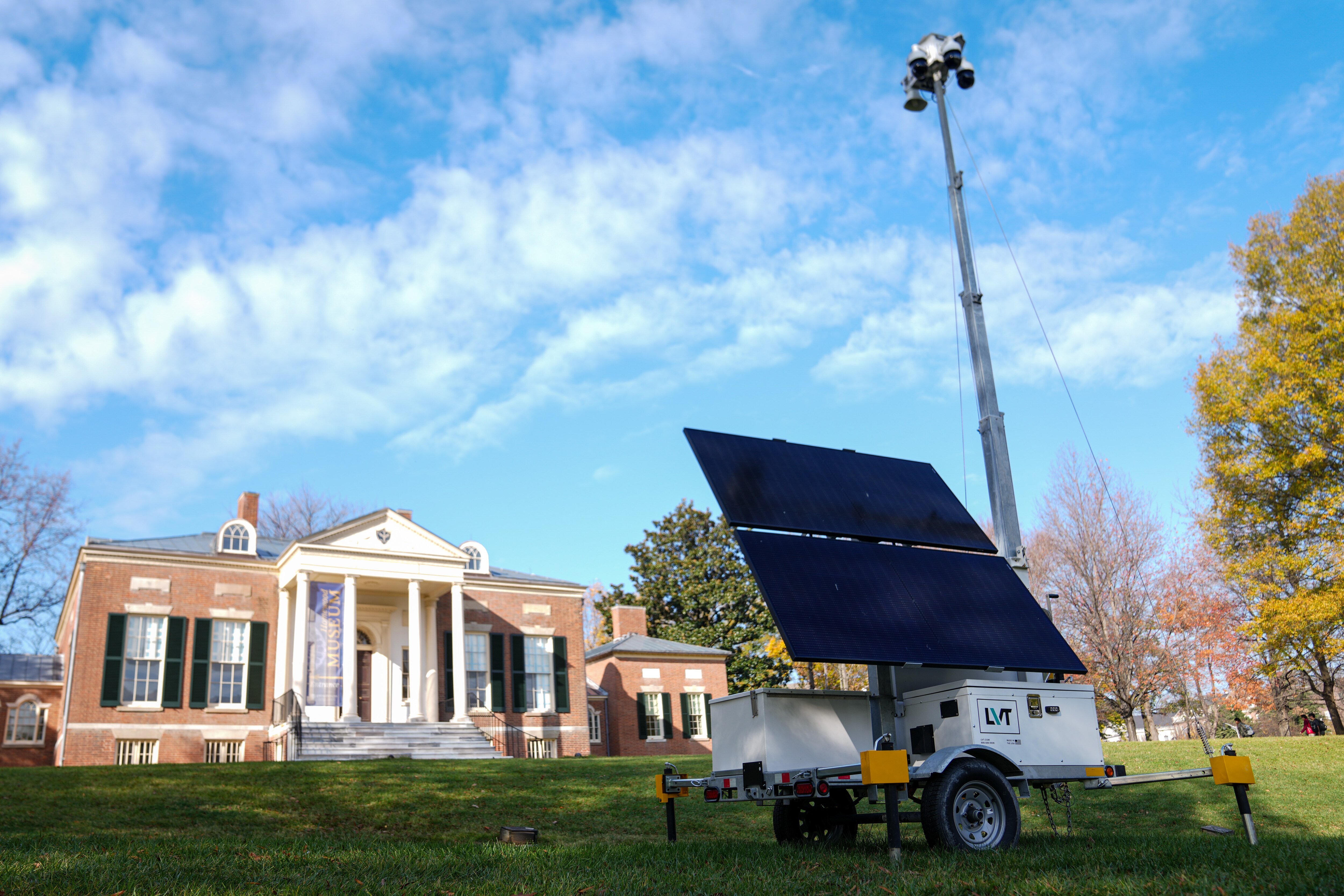 A mobile security camera on Johns Hopkins University’s Homewood campus looms over an open green space known as “the Beach.”