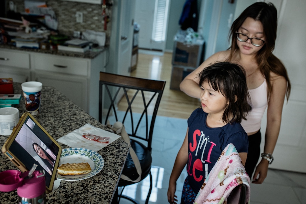 HAGERSTOWN, MD - July 22, 2026: Rachel Hoang, 19, brushes her sister, Riley’s hair, while she is on a video call with their mother, Melissa on July 22, 2026 in Hagerstown, Maryland. Rosem Morton for The Baltimore Banner