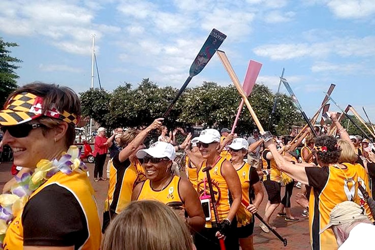 Chandra Jackson, second from left, runs through a tunnel of paddles with teammates.