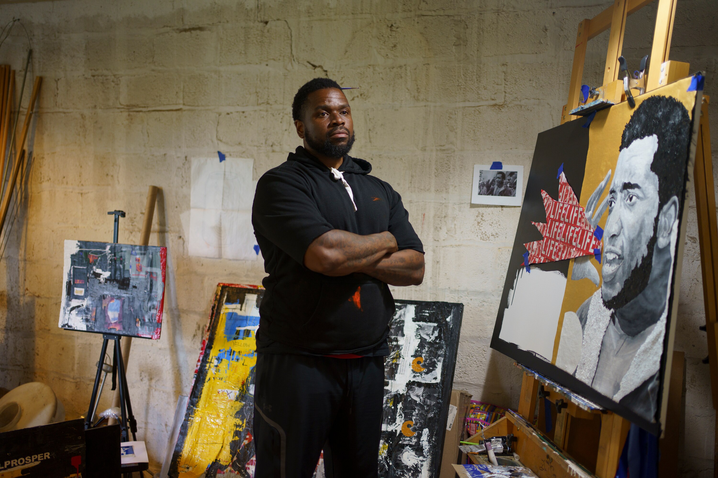 Waymond Harrison in his studio with his paintings, some of which are still in progress.