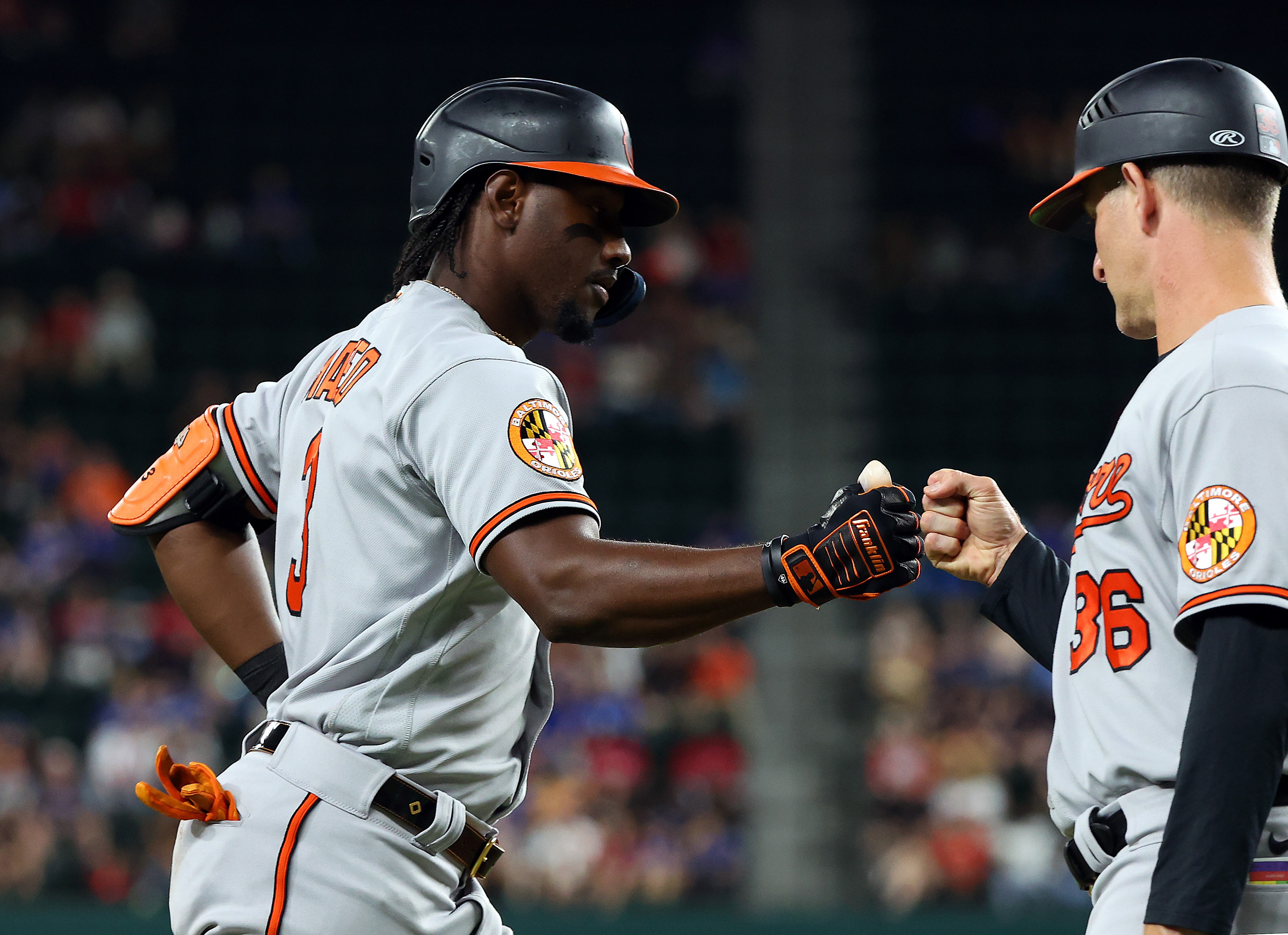 ARLINGTON, TEXAS - APRIL 03: Jorge Mateo #3 of the Baltimore Orioles fist bumps Tony Mansolino #36 as he rounds third base after a solo home run in the fifth inning against the Texas Rangers at Globe Life Field on April 03, 2023 in Arlington, Texas.