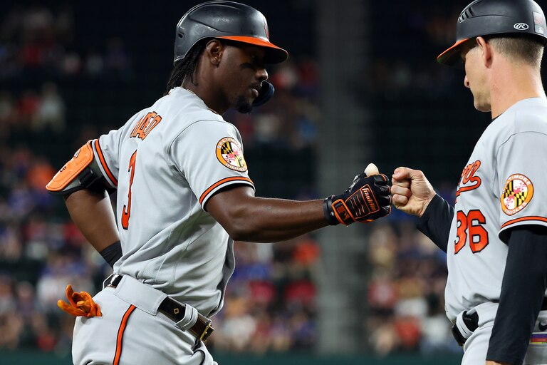 ARLINGTON, TEXAS - APRIL 03: Jorge Mateo #3 of the Baltimore Orioles fist bumps Tony Mansolino #36 as he rounds third base after a solo home run in the fifth inning against the Texas Rangers at Globe Life Field on April 03, 2023 in Arlington, Texas.