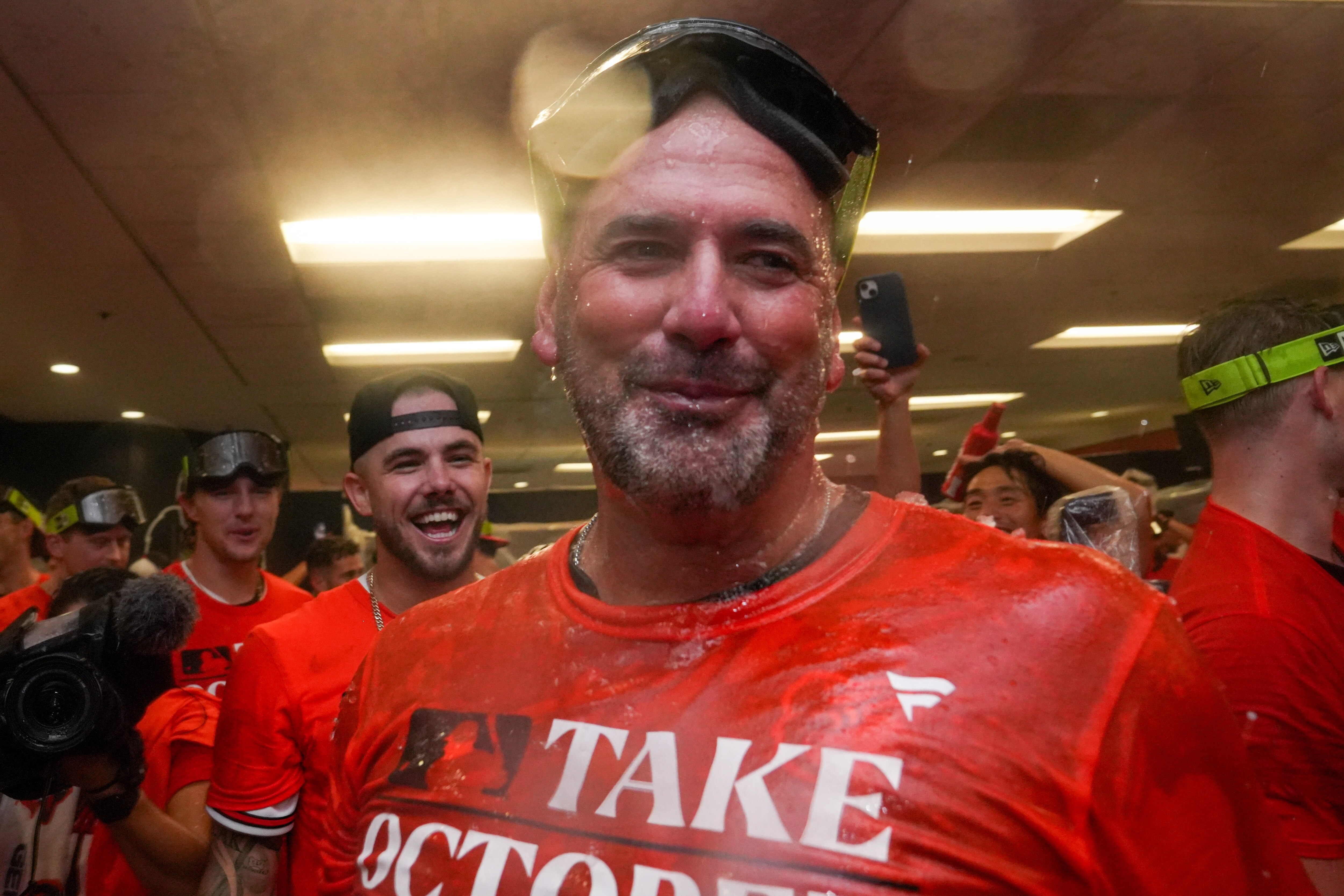 Baltimore Orioles manager Brandon Hyde smiles after drinking from the Homer Hose during the team’s celebration in the clubhouse following their playoff-clinching win against the Tampa Bay Rays on Sunday, September 17, 2023. The Orioles earned a spot in the playoffs for the first time since 2016.