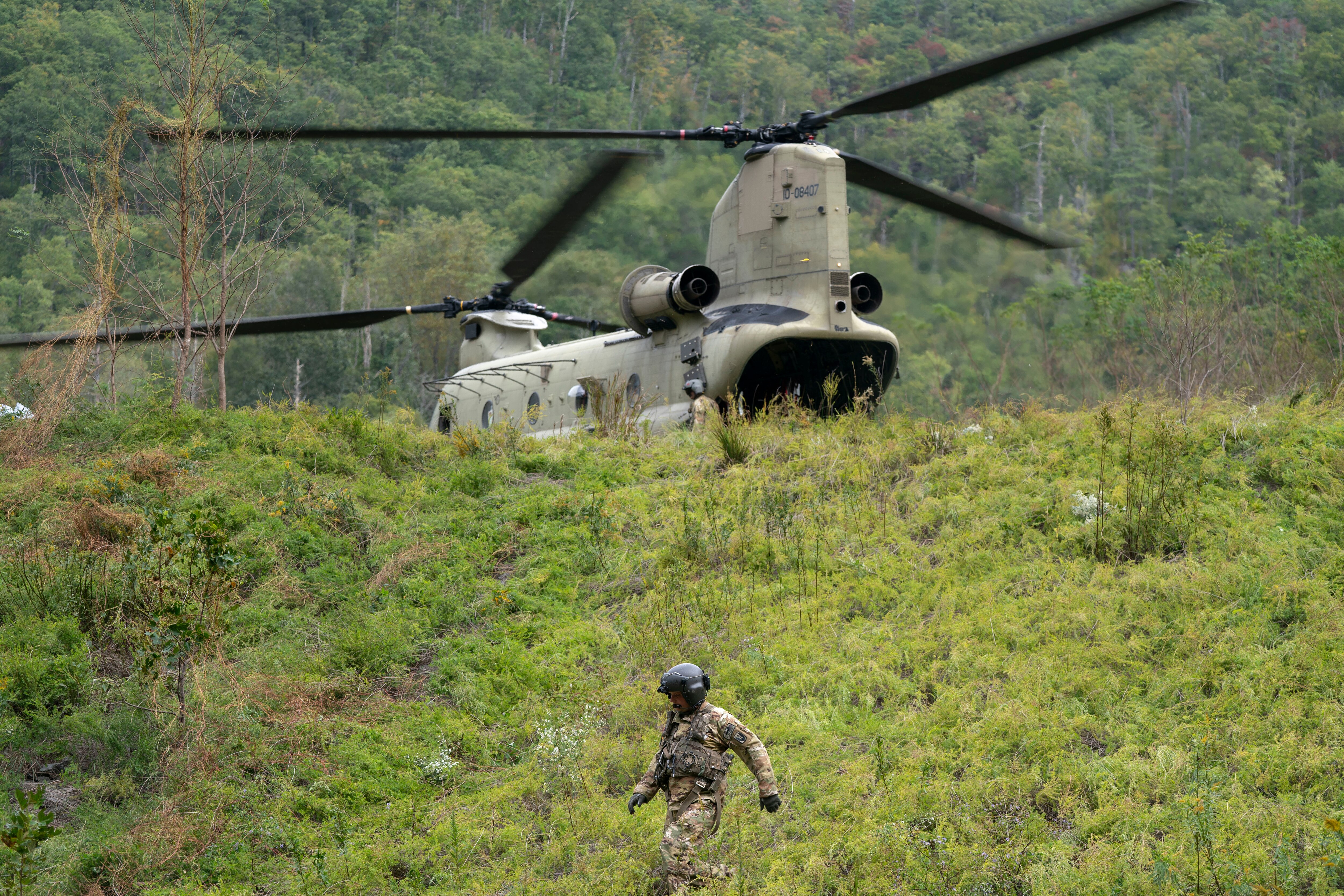 BAT CAVE, NORTH CAROLINA - OCTOBER 1: A member of the Maryland National Guard descends a hill at a supply drop point in the aftermath of Hurricane Helene on October 1, 2024 near Bat Cave, North Carolina. The death toll has topped 140 people across the southeastern U.S. due to the storm, according to published reports, which made landfall as a category 4 storm on Thursday. Millions are without power and the federal government has declared major disasters in areas of North Carolina, Florida, South Carolina, Tennessee, Georgia, Virginia and Alabama, freeing up federal emergency management money and resources for those states, according to the reports. (Photo by Sean Rayford/Getty Images)