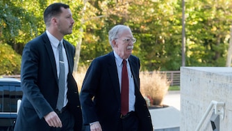 Former Trump administration national security adviser John Bolton, right, arrives for his arraignment at the Greenbelt Federal Courthouse in Greenbelt, Md., Friday, Oct. 17, 2025.