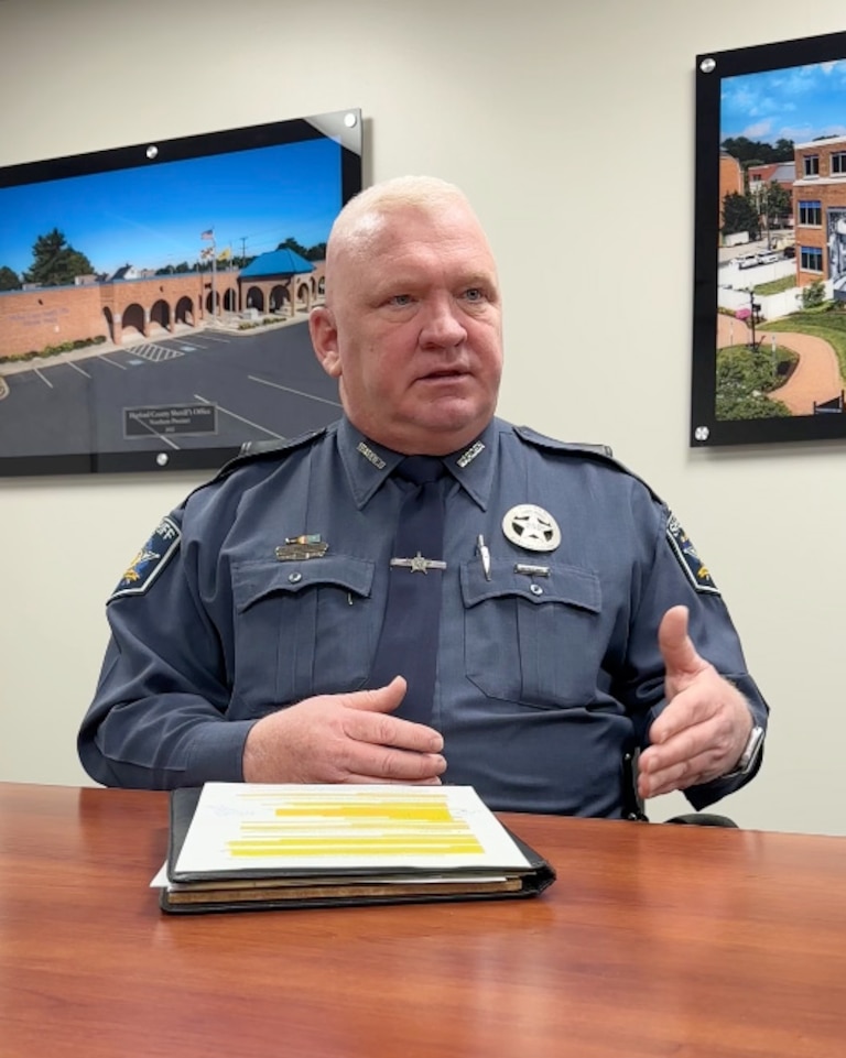 January 22, 2024 - Photograph of man seated at table speaking. He wears the uniform of a staff member of Harford County Detention Center.
