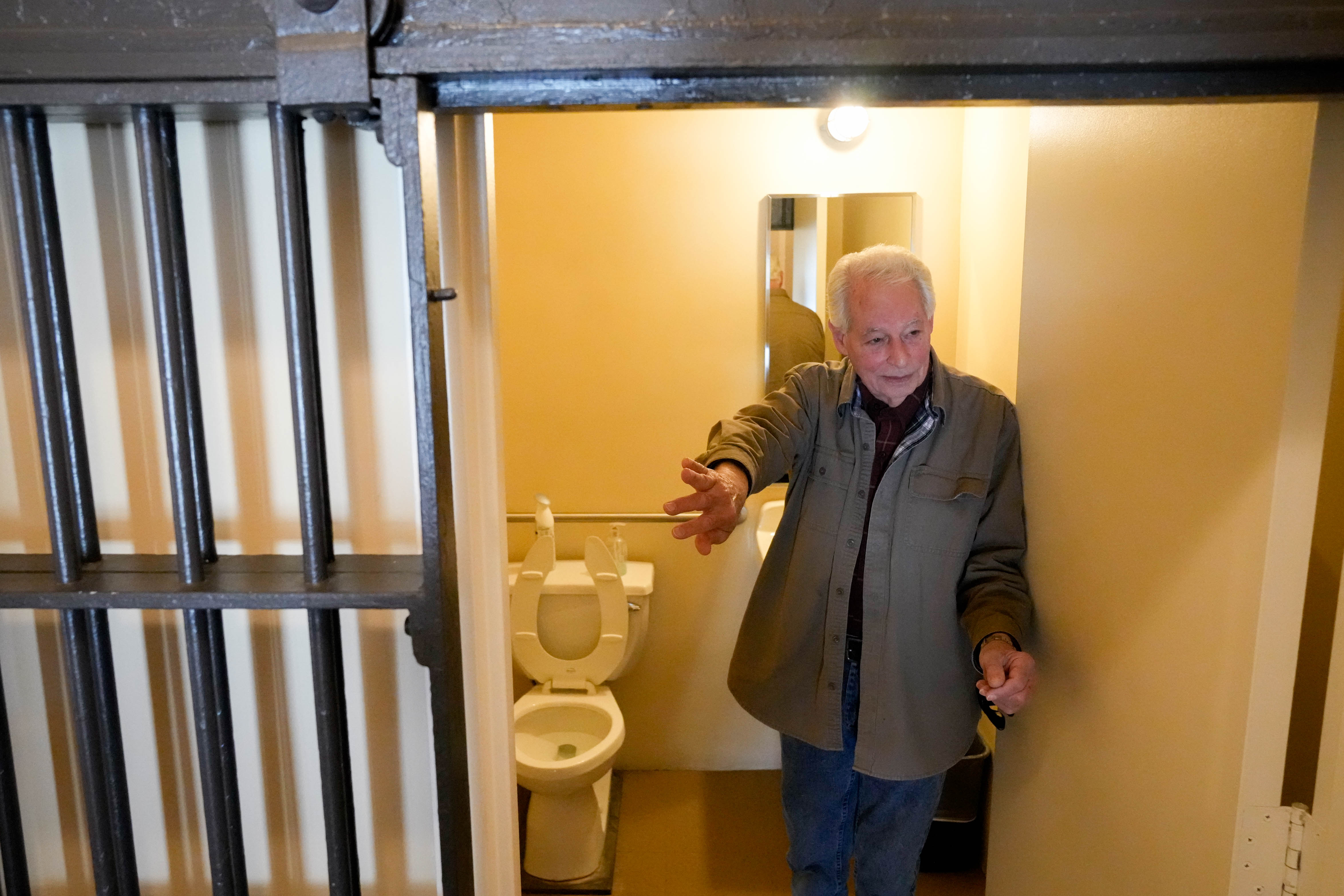 Historic preservationist Marty Azola gives a tour of a jail cell that has been repurposed into a bathroom at the Historic Towson Jail.