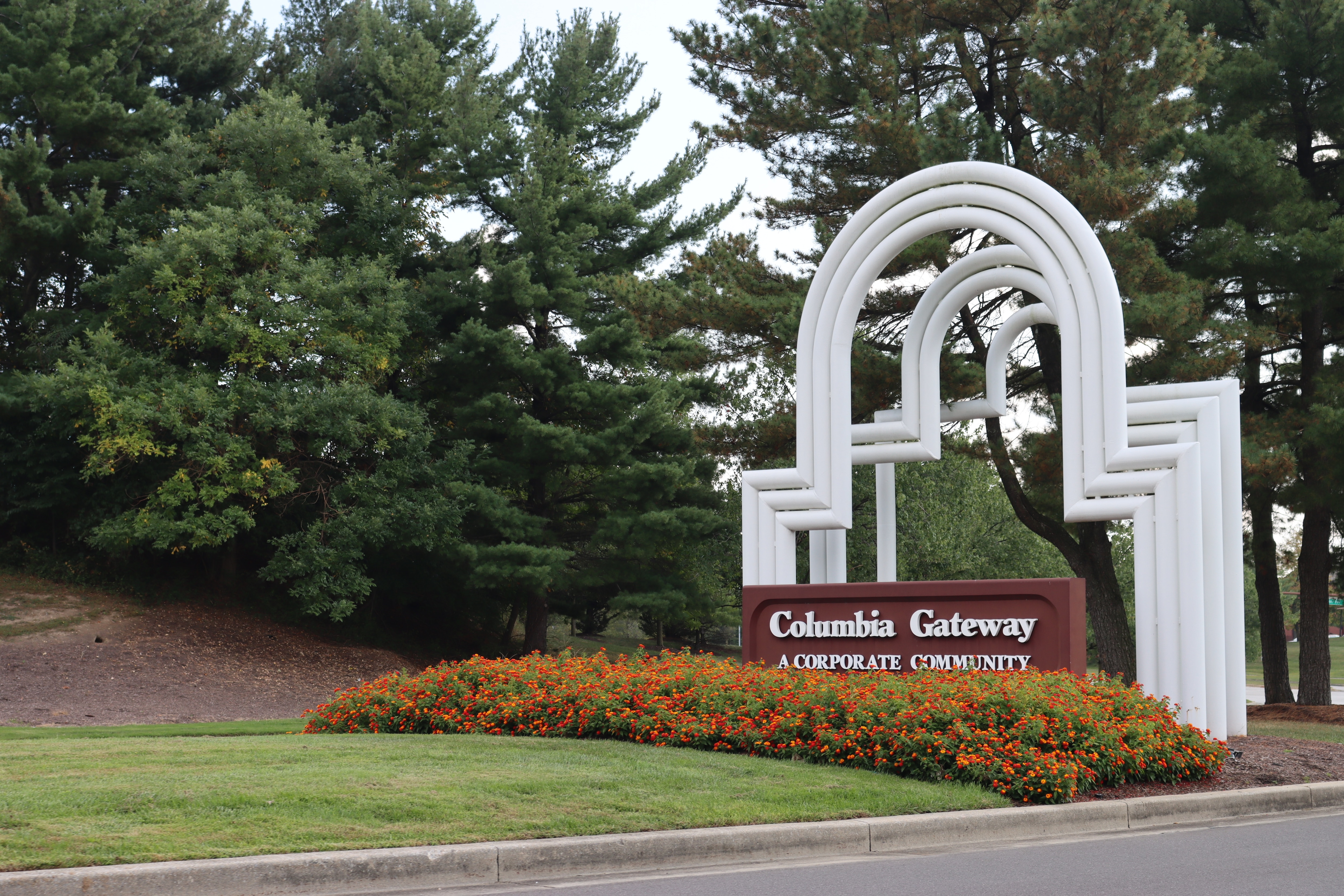 Curved, white arches stand over a sign that reads "Columbia Gateway: A Corporate Community"