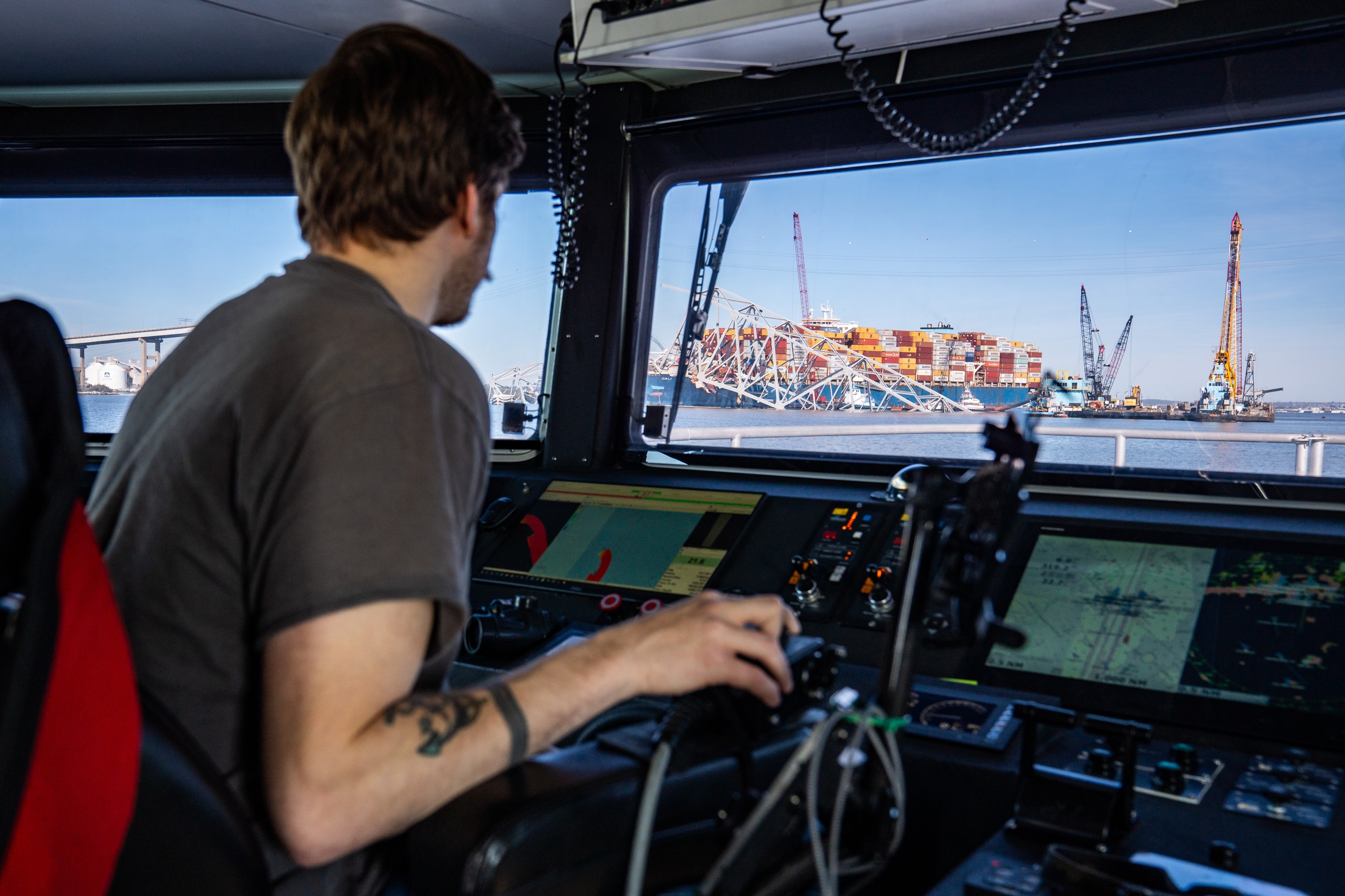 Jacob Tuer, assistant operator for the Catlett and the day’s captain, steers as the Dali and fallen Key Bridge are seen out the window on Tuesday, April 16, 2024.