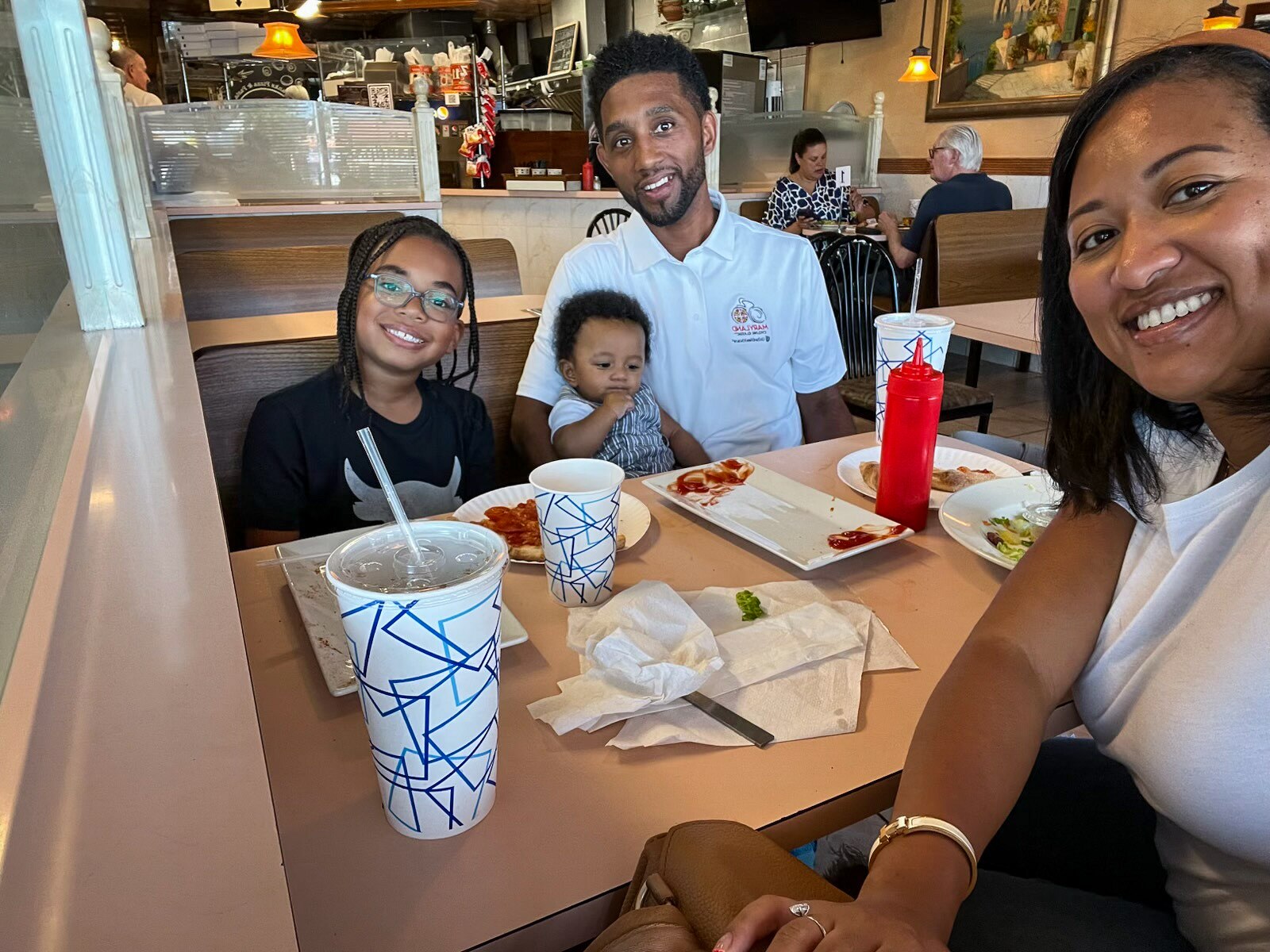 Hana Scott, right, with her husband Mayor Brandon Scott and two sons Ceron and baby Charm at Frank’s Pizza & Pasta.