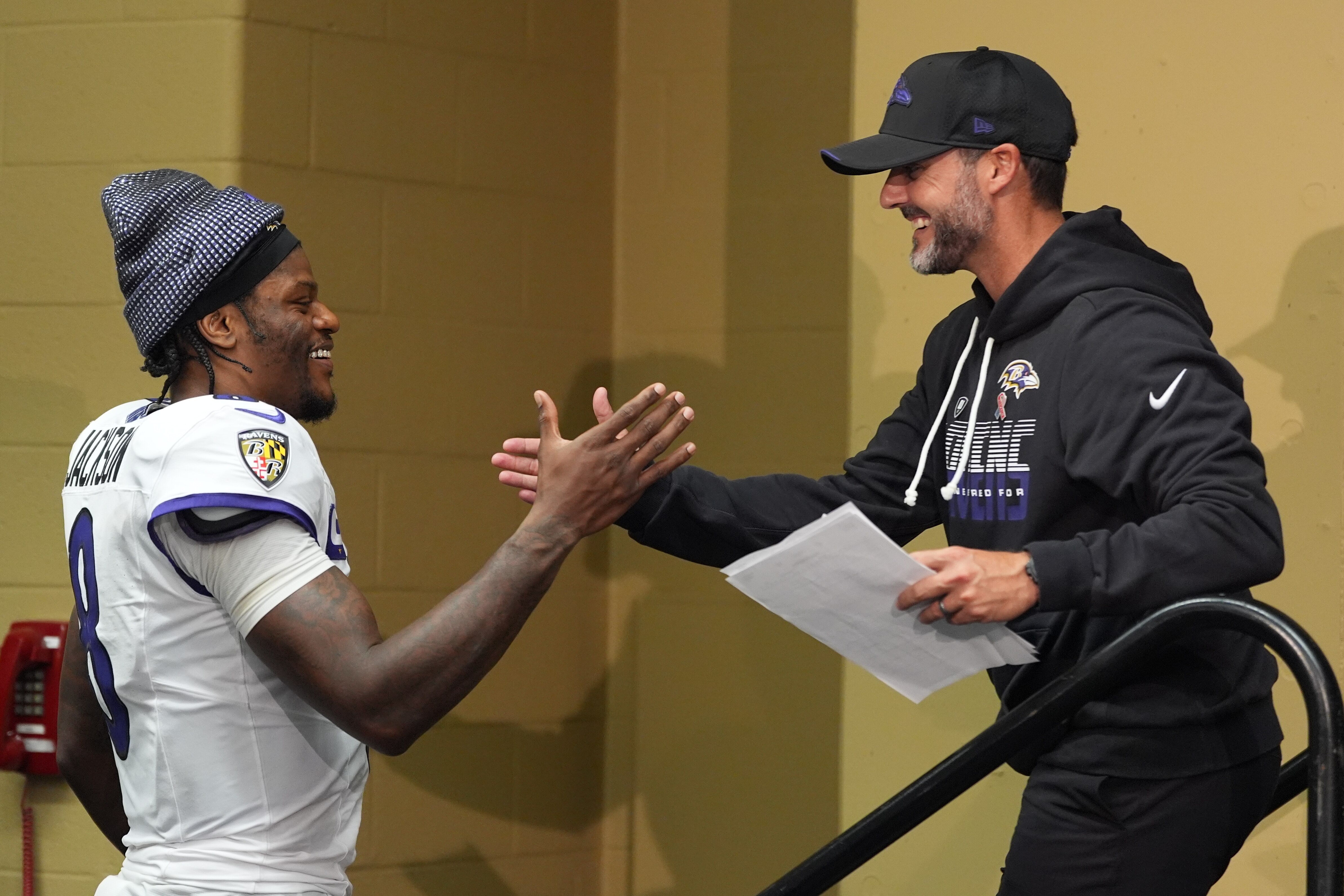Baltimore Ravens head coach Jesse Minter shakes hands with Lamar Jackson after an NFL football game Sunday, Sept. 13, 2026, in Indianapolis.