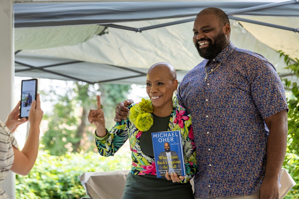 Former Baltimore Ravens player Michael Oher poses for a picture with Monique Smith during a book signing event at The Ivy Bookshop in Baltimore, MD on Monday, August 21, 2023. Oher was signing fan’s copies of his new book “When Your Back’s Against the Wall”, but provided no comments to media in regards to his recent petition to end the Tuohy’s  conservatorship. 