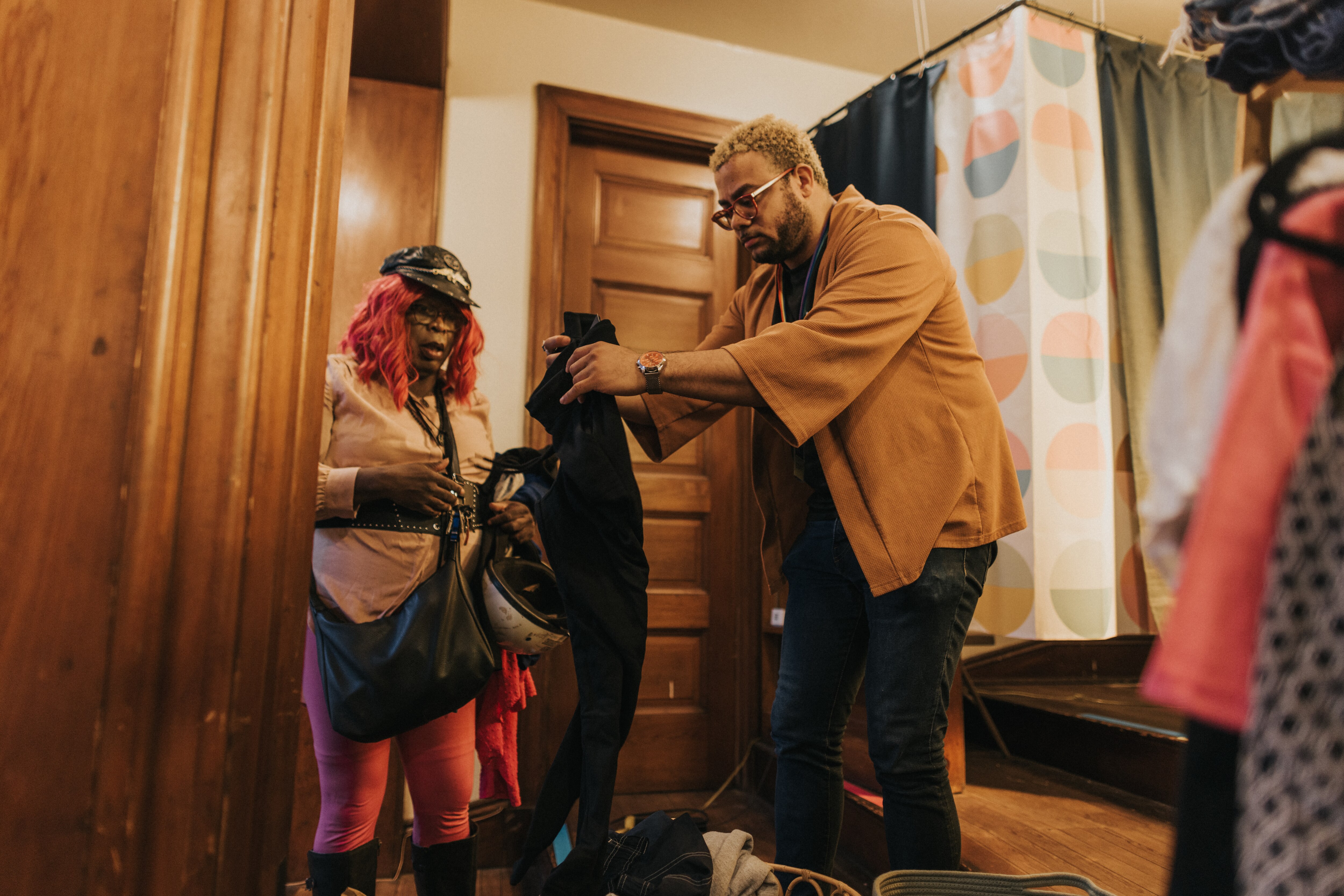 Phillip Clark, a volunteer at skylight boutique, helps a customer find their size at St. Mark’s Lutheran Church in Baltimore on Sunday, Oct. 13, 2024.