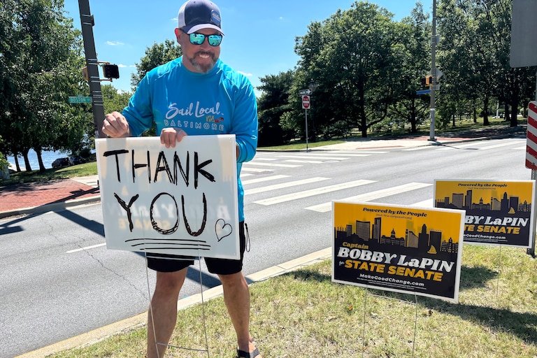 Bobby LaPin writes thank you on the back of a campaign sign the morning after his primary loss to Senate President Bill Ferguson.