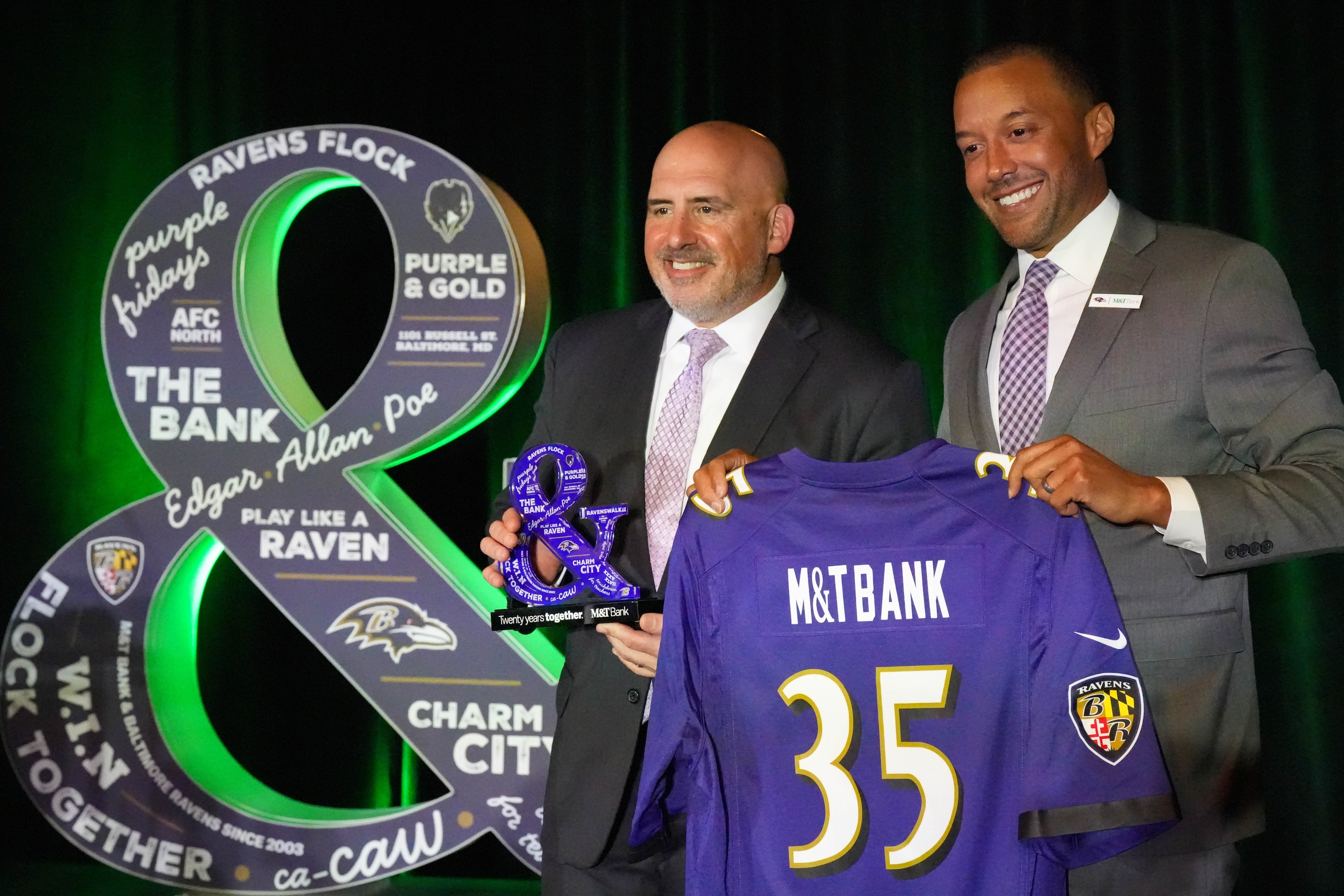 Augie Chiasera, regional president of M&T Bank, left, and Sashi Brown, president of the Baltimore Ravens, pose for a photo together during a press conference celebrating the partnership between the Ravens and M&T Bank on Thursday, April 20. The two organizations marked 20 years of partnering together this year, and announced that they will extend that deal for another 15 years.
