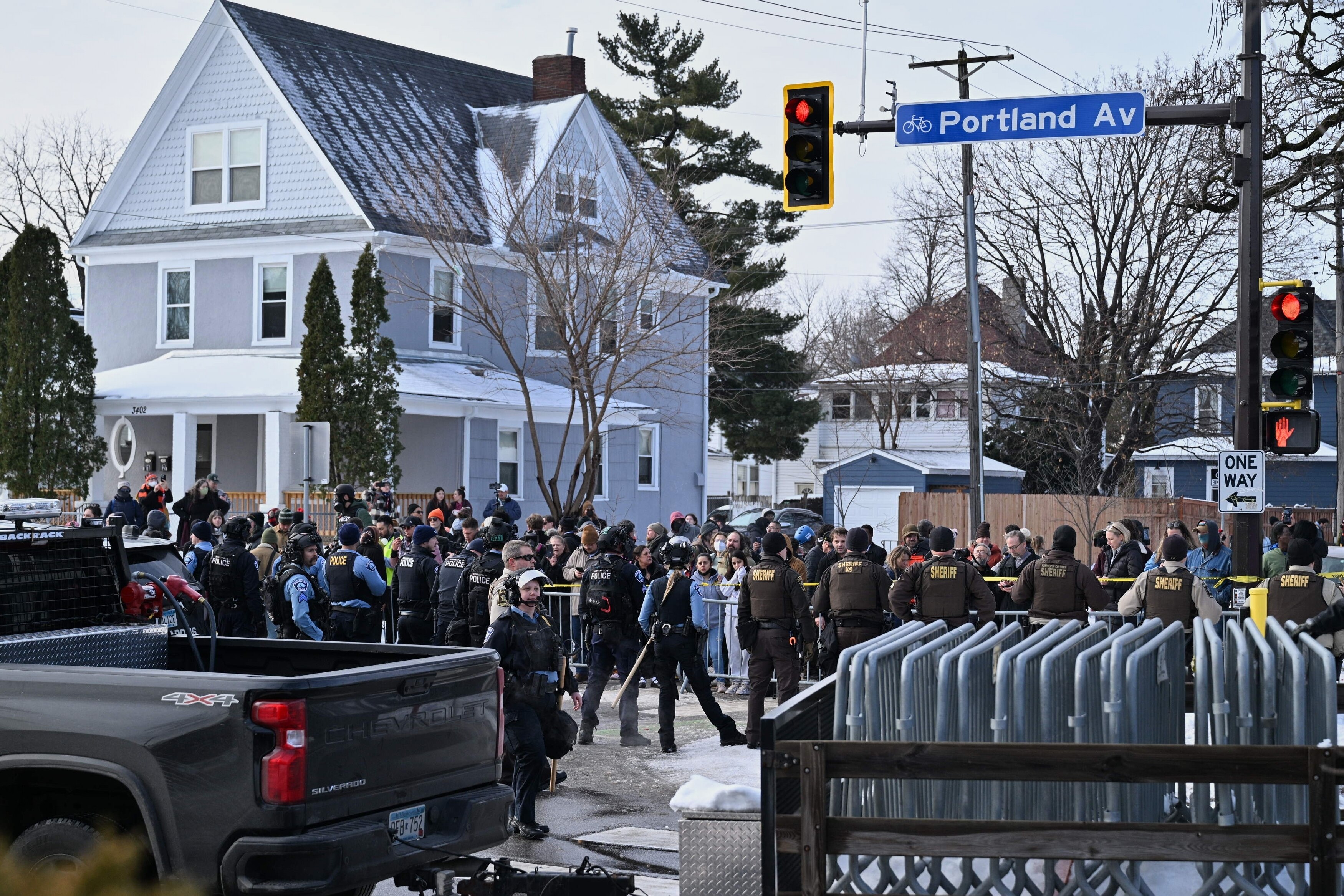 People protest as law enforcement officers attend to the scene of the shooting involving federal law enforcement agents, Wednesday, Jan. 7, 2026, in Minneapolis. (AP Photo/Tom Baker)
