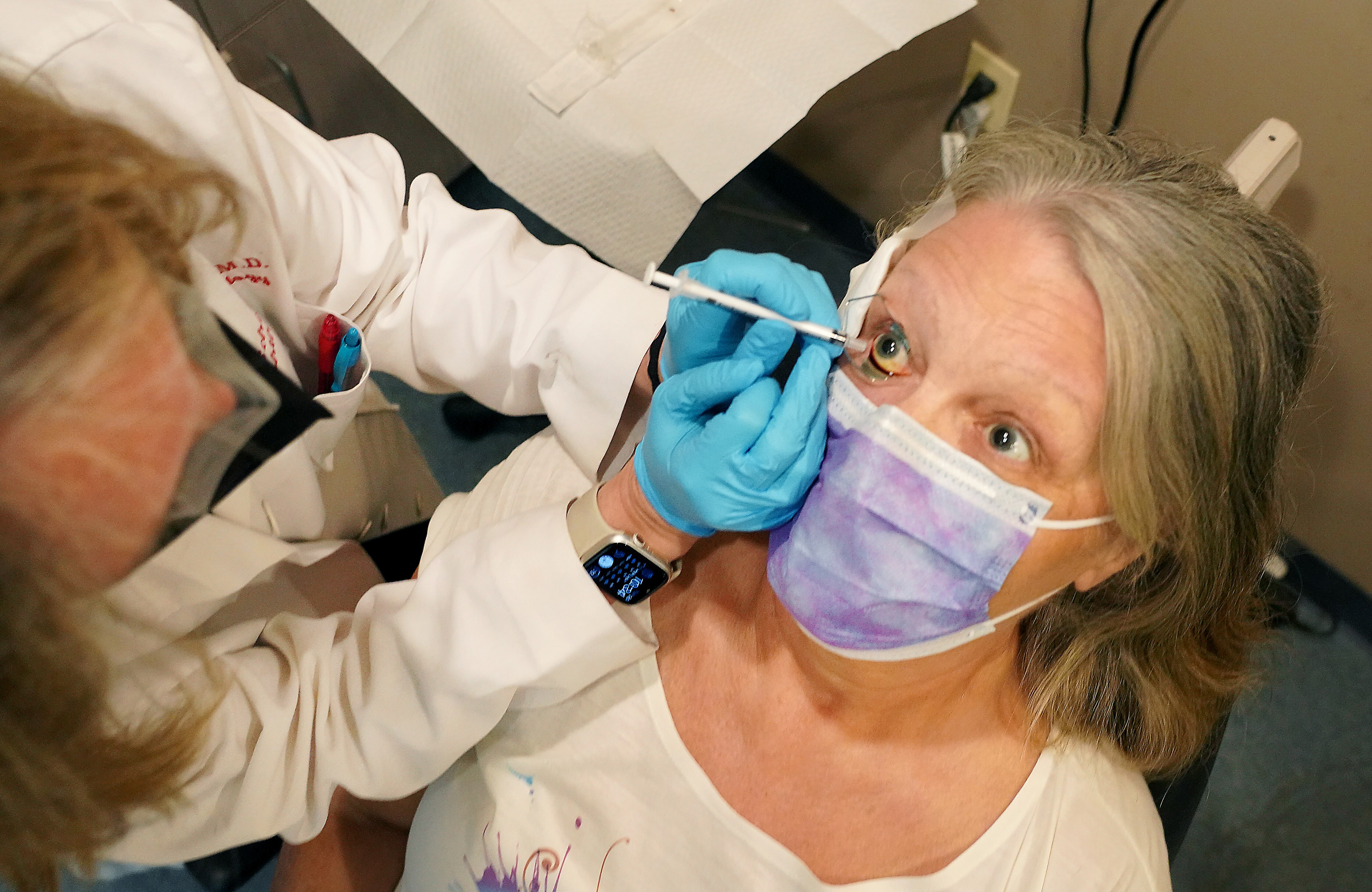 Debra Grigsby, 70, retired nurse from Carroll County, receives a shot in her eye from Dr. Lisa Schocket of the University of Maryland for age-related macular degeneration. The injection will slow the progression of the eye condition. It’s especially prevalent in older adults and has no cure — it can only be slowed. More people are getting diagnosed with the disease as a consequence of living longer.