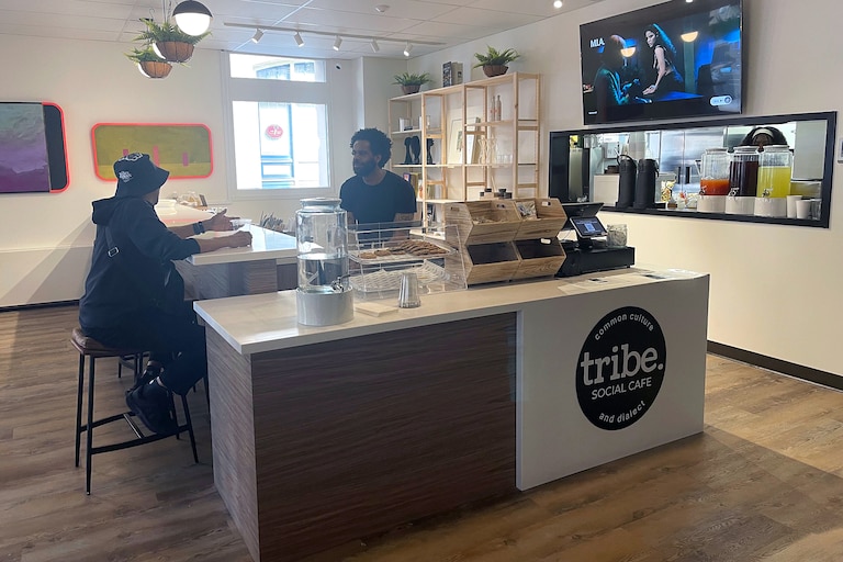 Owner Levi sits and chats with regular customer Christopher Bess. Levi's goal was to have Tribe Social be meshed in the community.