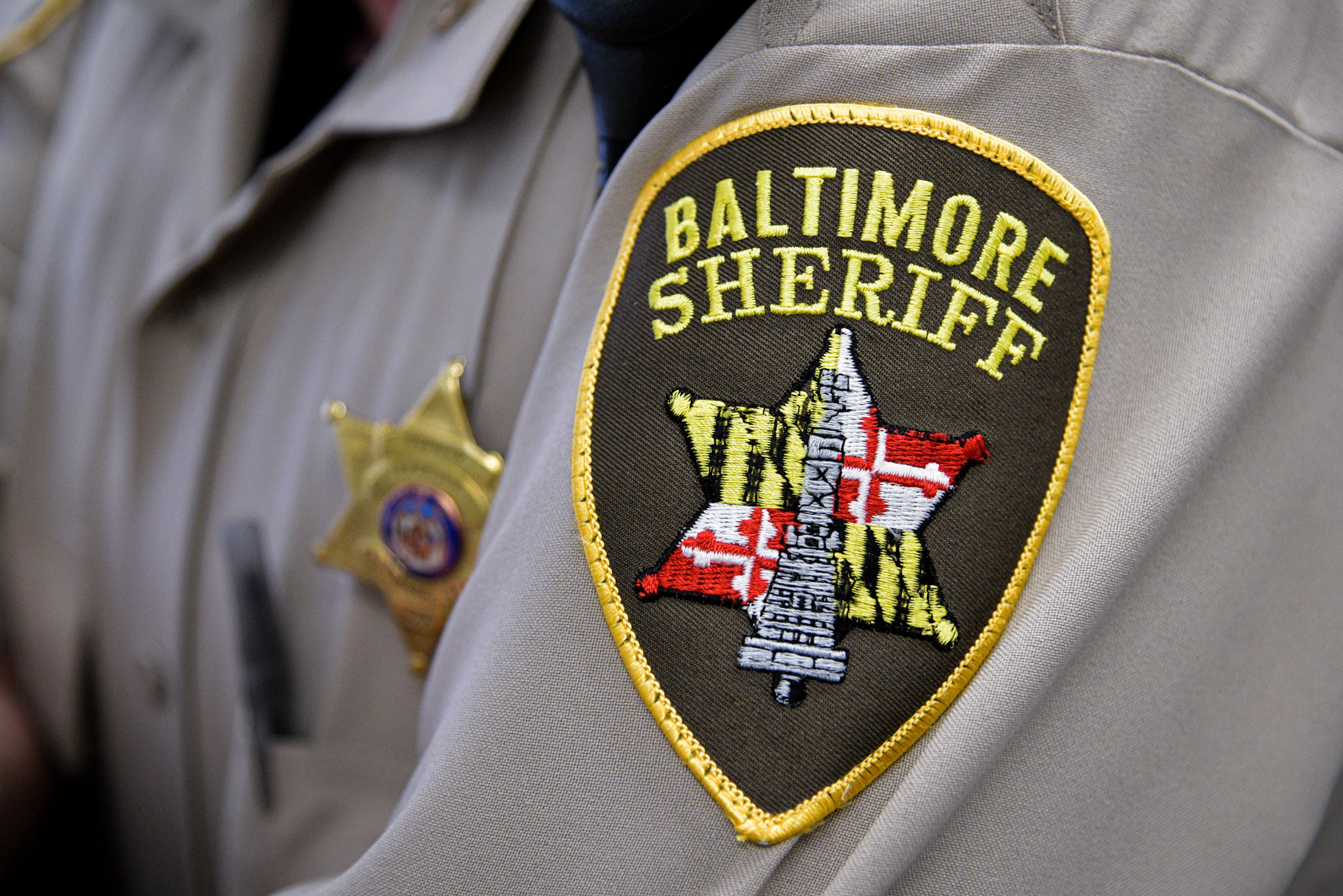 A logo patch on a Baltimore City Sheriff’s Office deputy’s uniform sleeve.