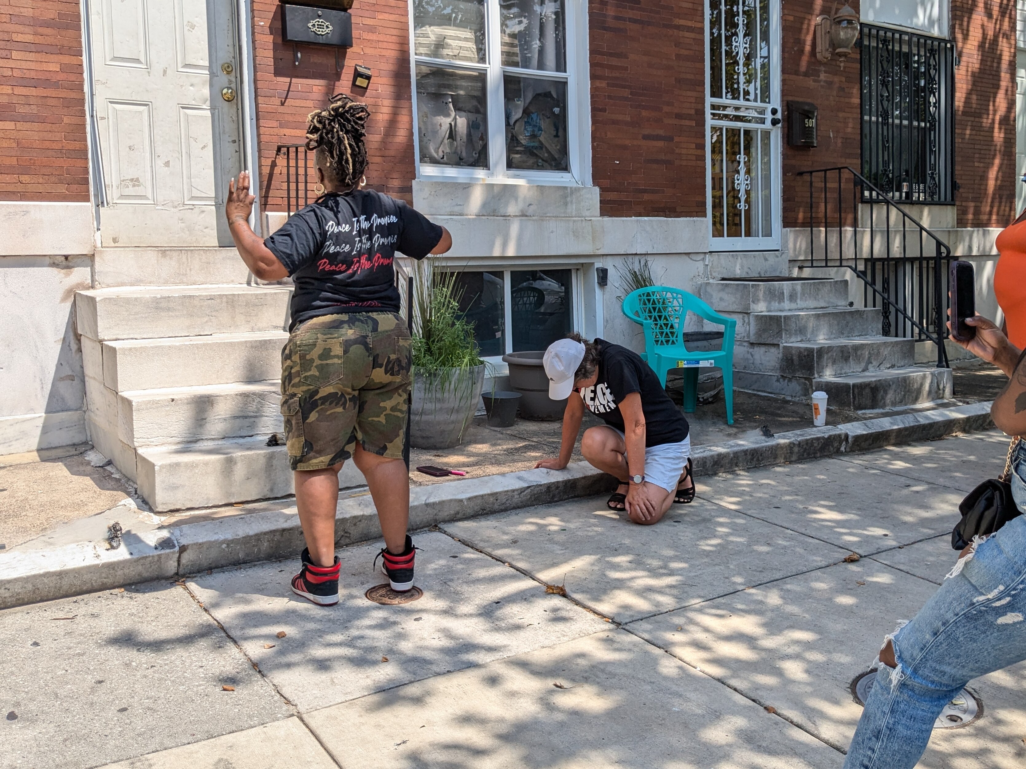This is a picture of Erricka Bridgeford leading a "sacred space" ritual in front of the East Baltimore home where Breaunna Cormley was killed.