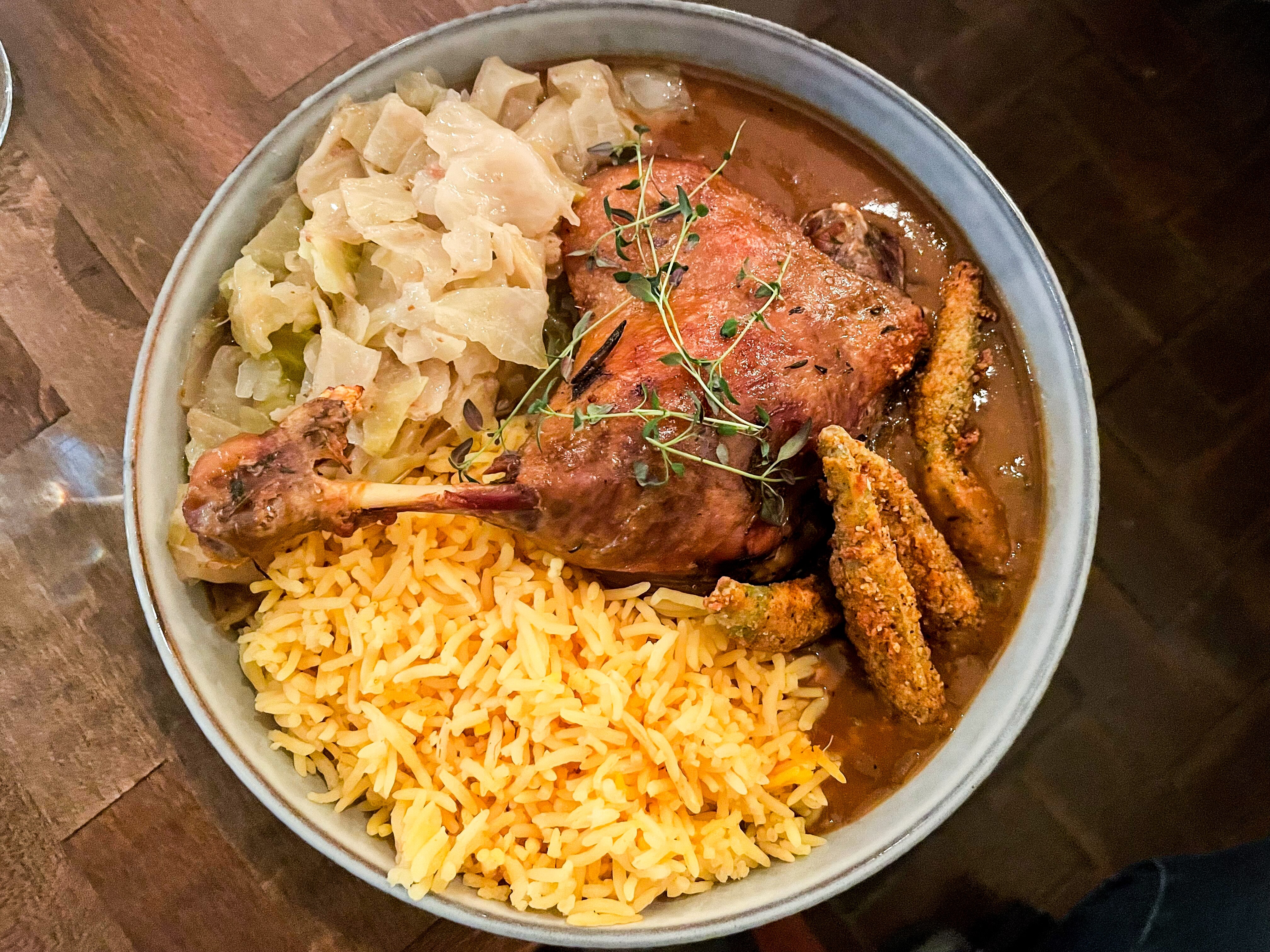 The duck confit gumbo from Rooted Rotisserie is served with cabbage, fried okra and rice.