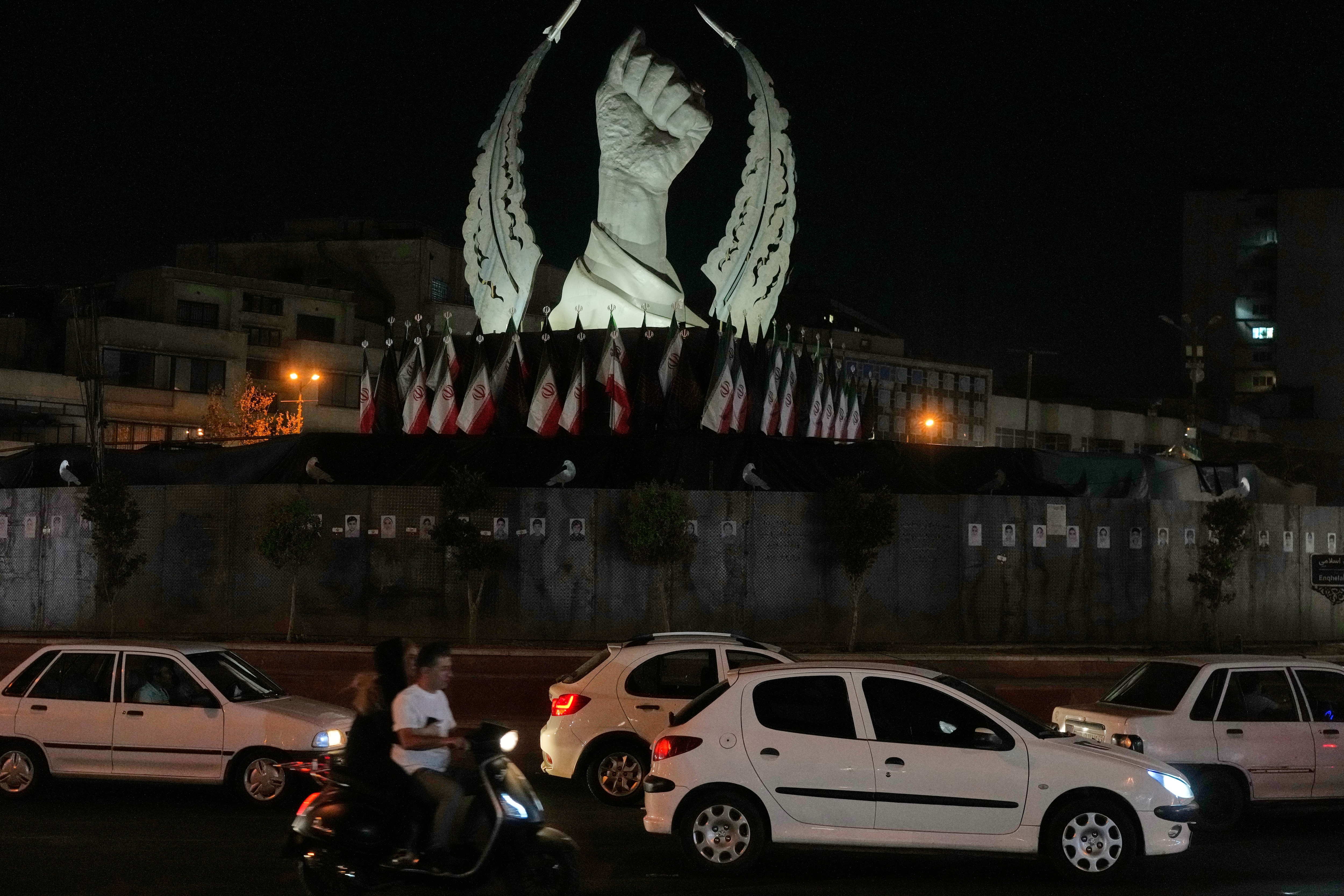 Vehicles drive past a monument depicting the clenched fist of the late Iranian Supreme Leader Ayatollah Ali Khamenei, who was killed in the U.S. and Israel strike on Feb. 28, in Islamic Revolution Square in Tehran, Sunday, July 19, 2026.