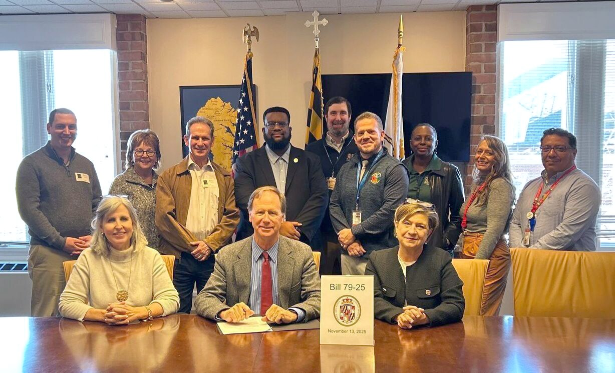 Anne Arundel County Executive Steuart Pittman, seated center, Councilwoman Julie Hummer, seated left, and Councilwoman Allison Pickard, seated right, after signing bill 79-25 into law on Thursday, November 13, 2025.