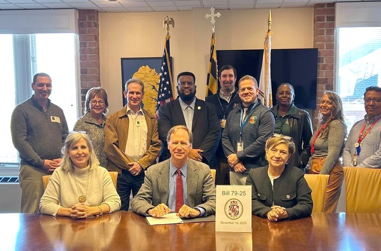 Anne Arundel County Executive Steuart Pittman, seated center, Councilwoman Julie Hummer, seated left, and Councilwoman Allison Pickard, seated right, after signing bill 79-25 into law on Thursday, November 13, 2025.