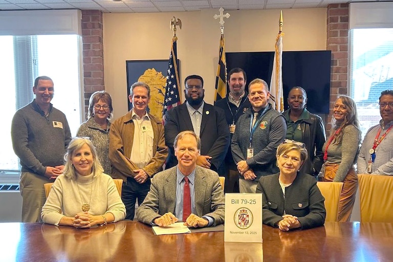Anne Arundel County Executive Steuart Pittman, seated center, Councilwoman Julie Hummer, seated left, and Councilwoman Allison Pickard, seated right, after signing bill 79-25 into law on Thursday, November 13, 2025.