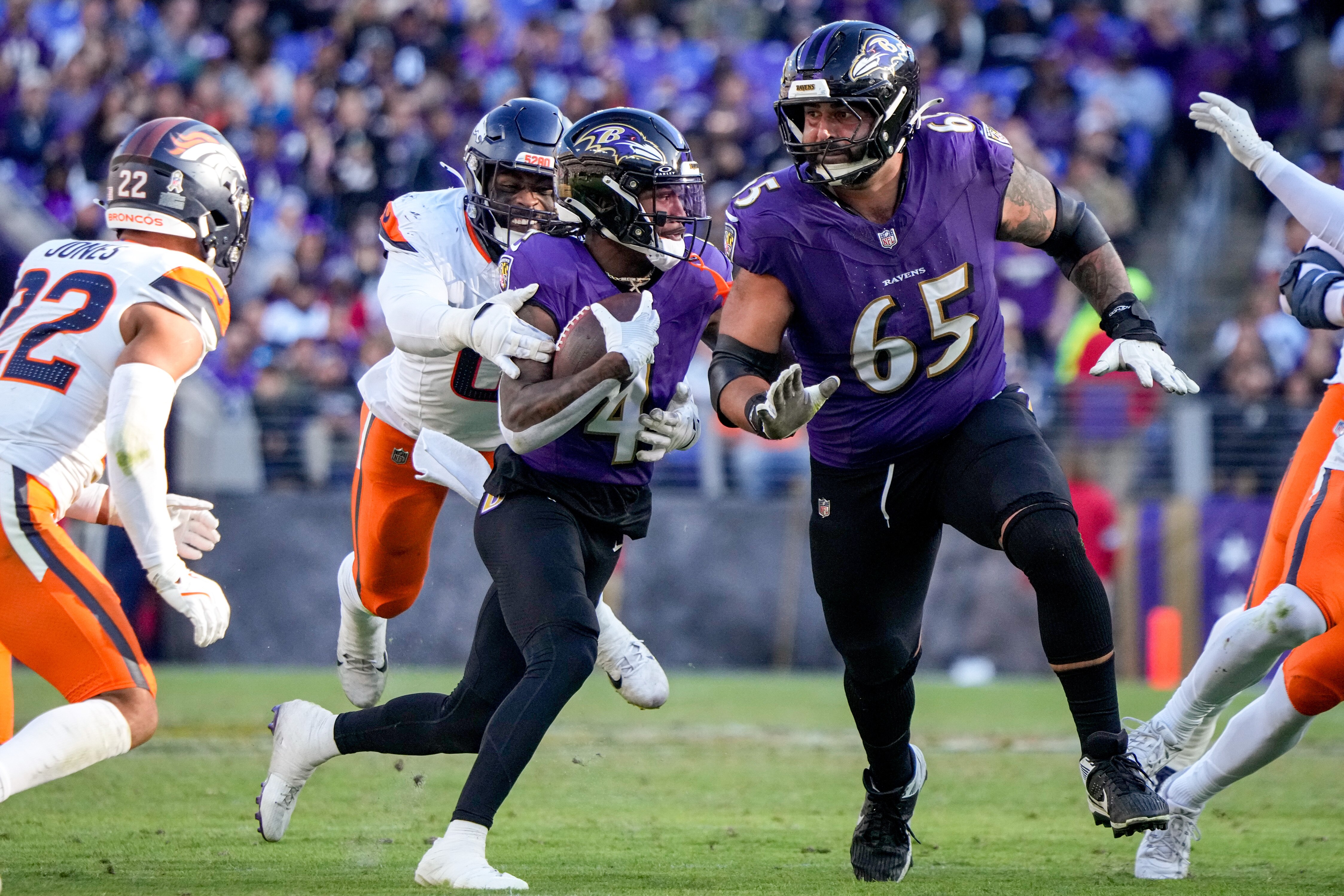 Baltimore Ravens wide receiver Zay Flowers (4) is guarded by guard Patrick Mekari (65) as he tries to outrun Denver Broncos linebacker Jonathon Cooper (0) in a regular season game at M&T Bank Stadium on Sunday, November 3, 2024.