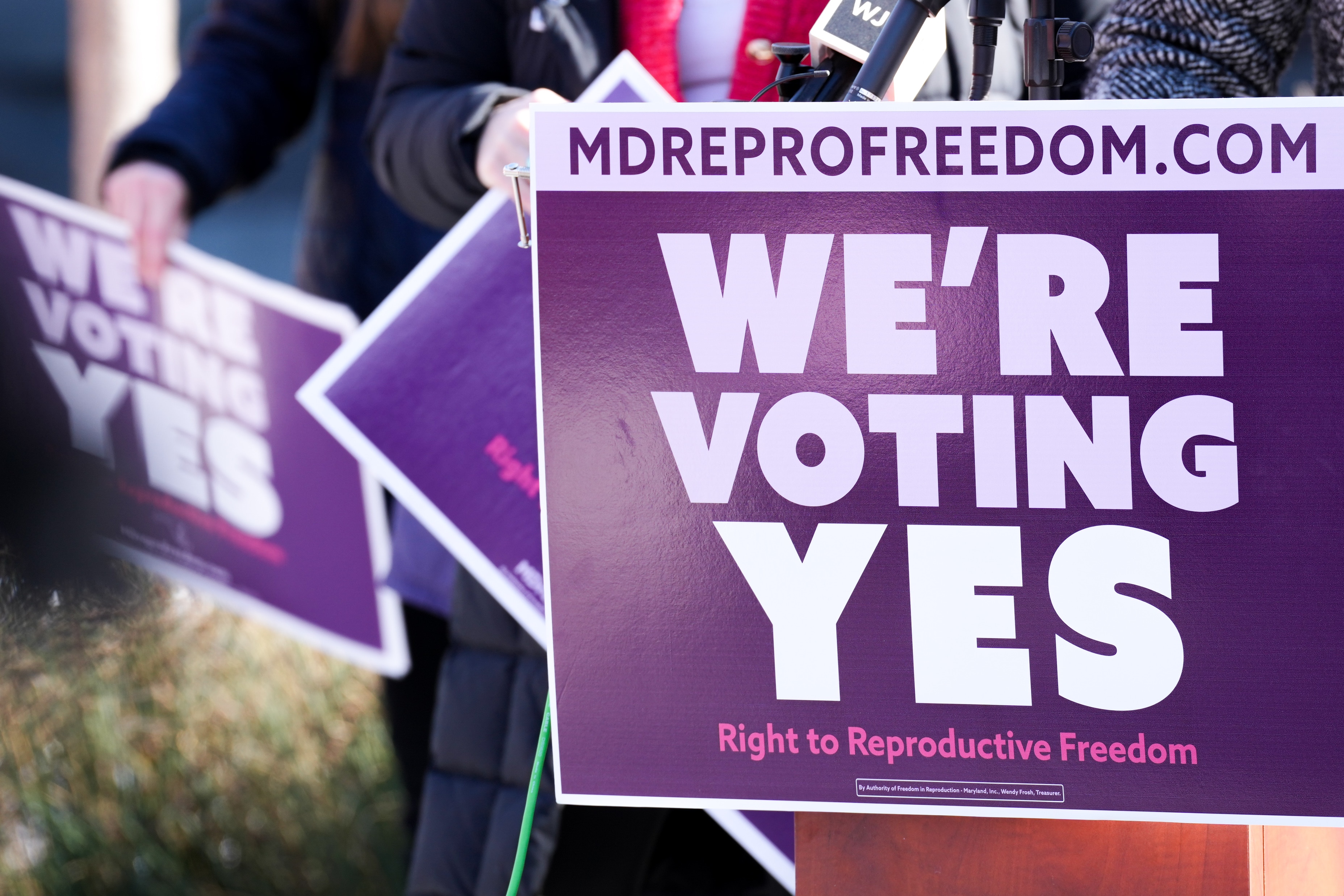 Supporters hold “We’re Voting Yes” signs at a reproductive rights press event on Lawyers Mall outside the Maryland State House in January.