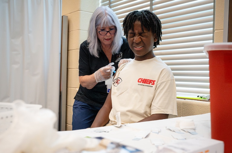 Reva Bounan, RN administers a vaccine injection to Ryan Lewis (11) during a Vaccine Clinic offered at BCPS Fest held at New Town High School on August 16th, 2025 in Owings Mills, MD.