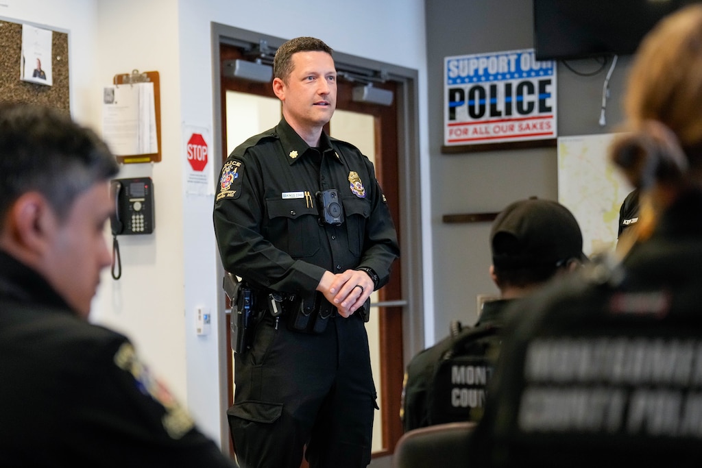 Capt. Jason Cokinos, District 3 area commander, center left, speaks with officers on his team following a roll call meeting at the Montgomery County Police Department’s District 3 headquarters in Colesville, Md. on Tuesday, April 7, 2026.