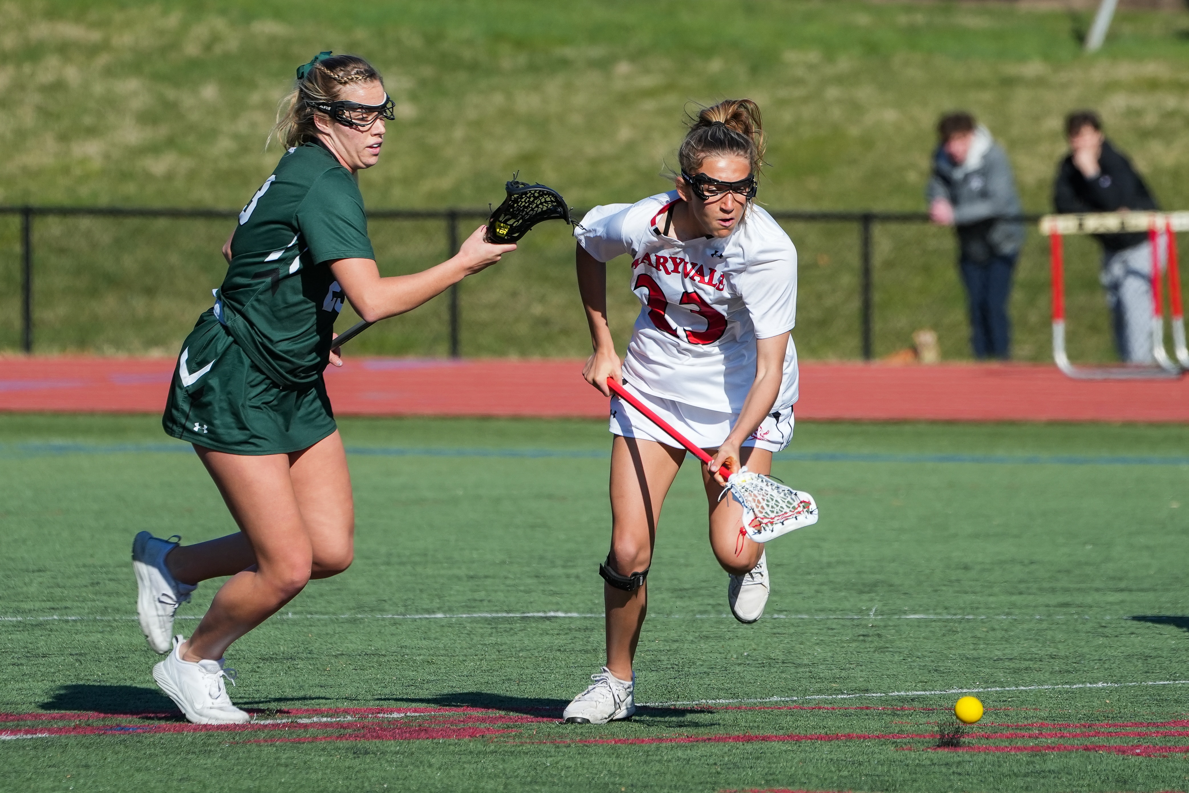 Maryvale freshman Cayden Reese (23) sprints for possesion of the ball against Senior Anna Regan (12) at Maryvale Preparatory School, on March 30, 2023. Maryvale lost to St. Paul 9-8.