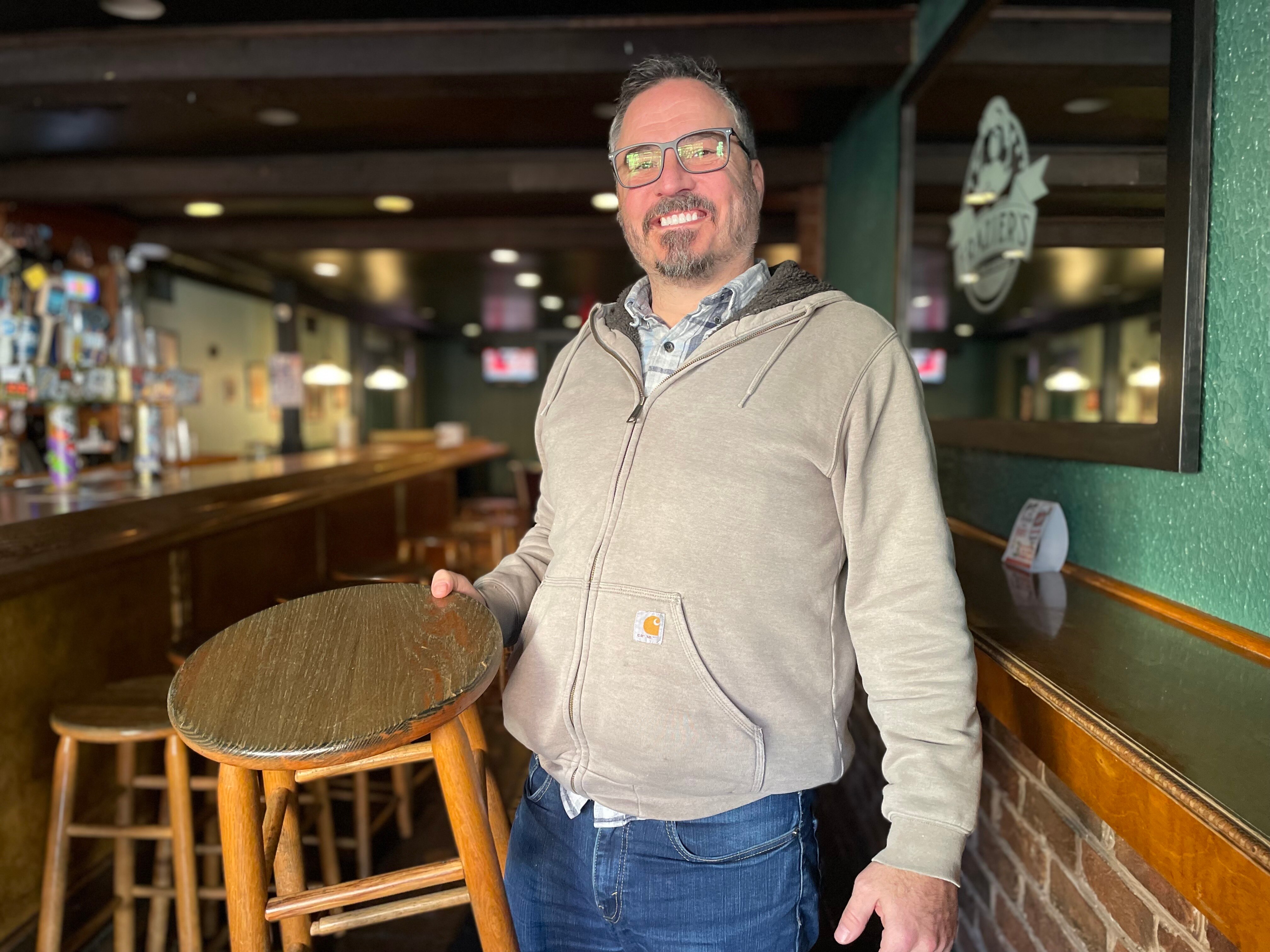 Bar owner Morgan King stands with a stolen barstool that was returned to the bar Wednesday morning.