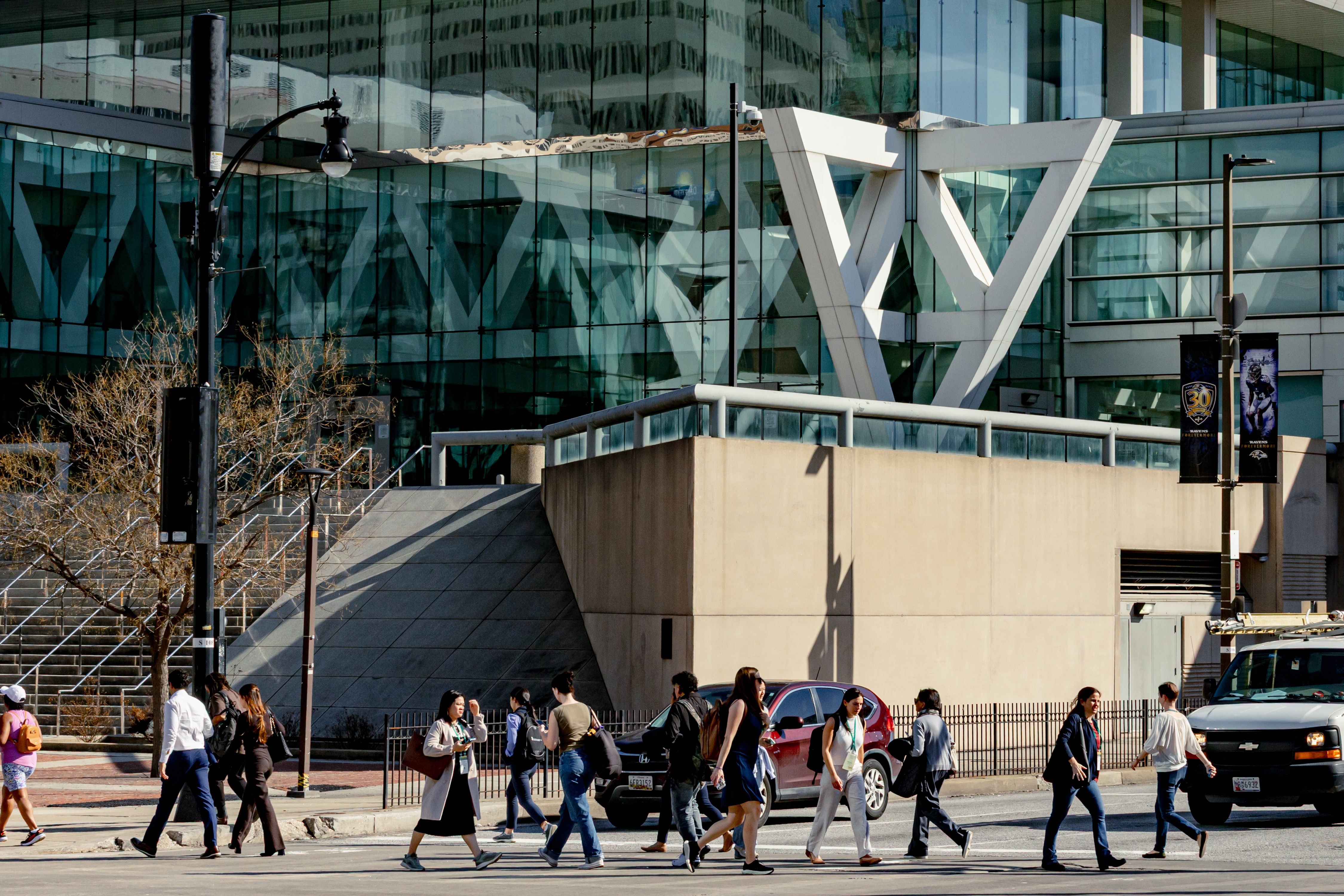 People walk along Pratt Street past the Baltimore Convention Center.