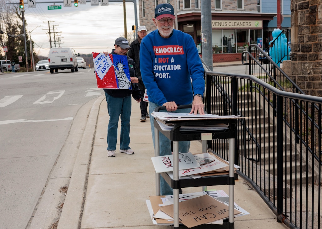 Karl Alexander pushes a cart full of signs back to Roland Park Place after the weekly protest wraps.
